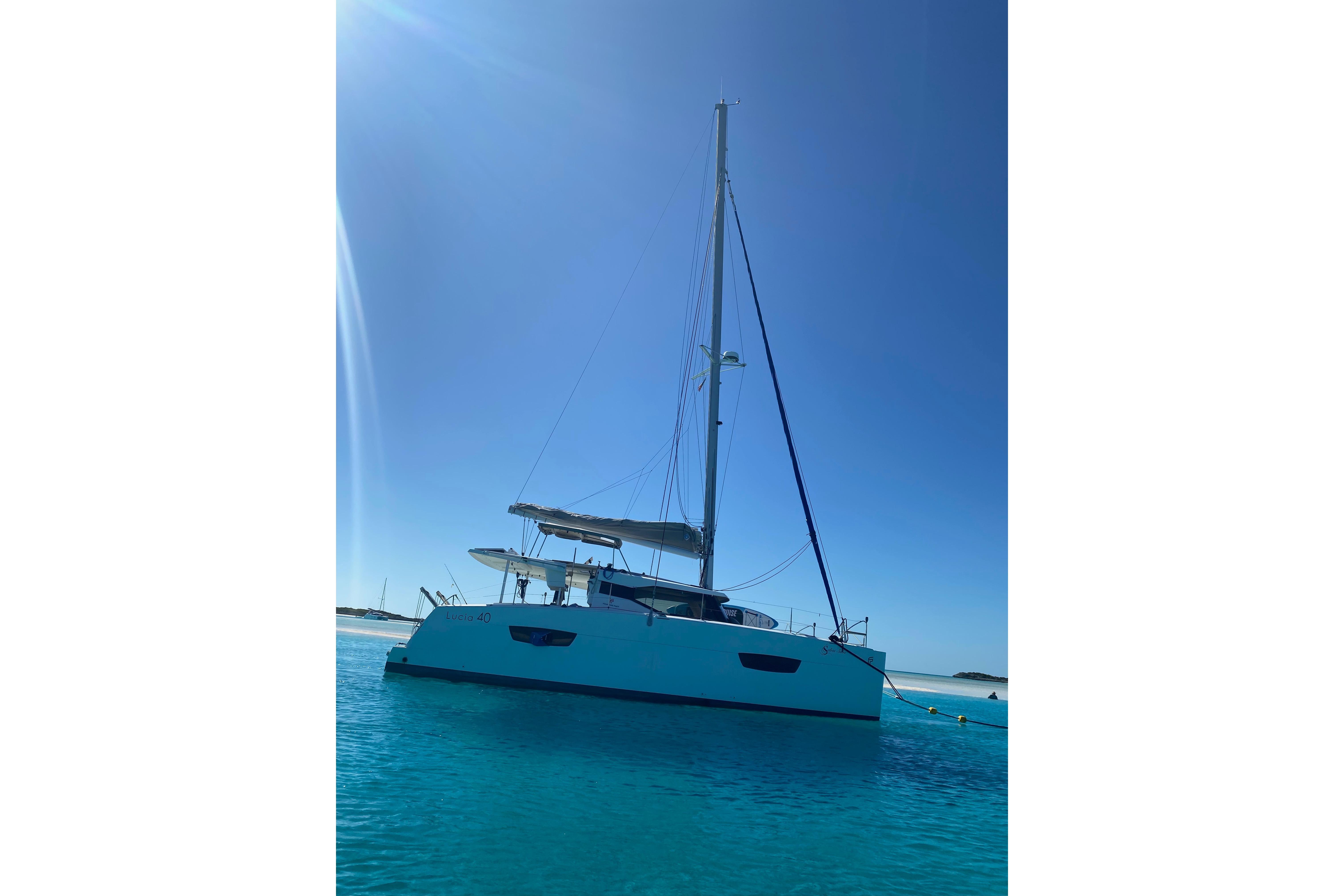 2018 Fountaine Pajot Lucia 40 catamaran sailing on clear blue waters.