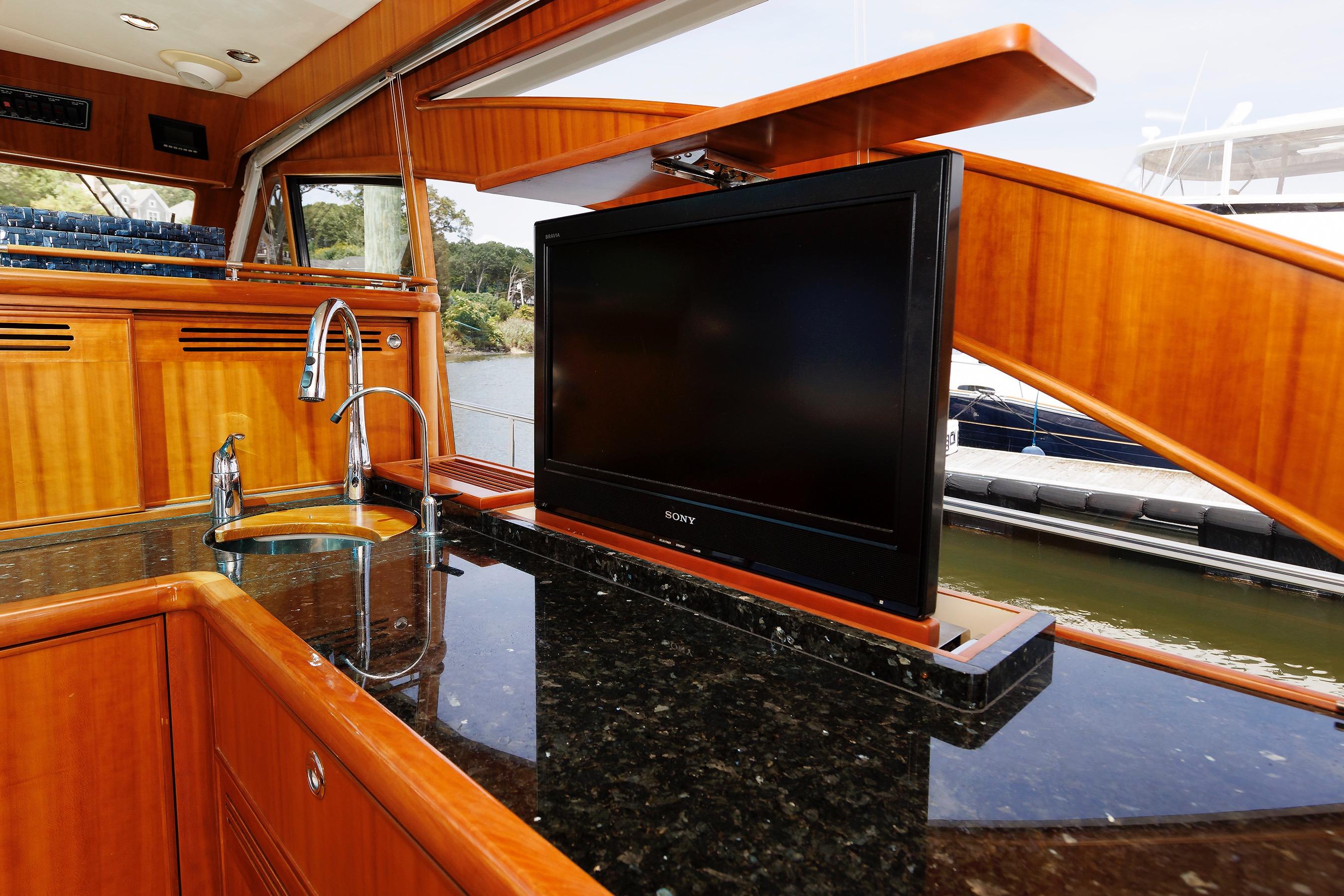 Luxurious 2009 Hunt Yachts 52 Express interior with sleek kitchen and pop-up TV.