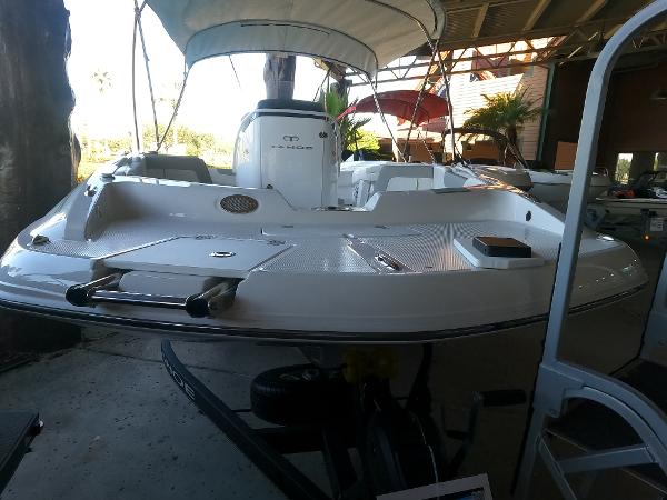 2023 Tahoe 2150 CC boat with canopy in a covered dock area.