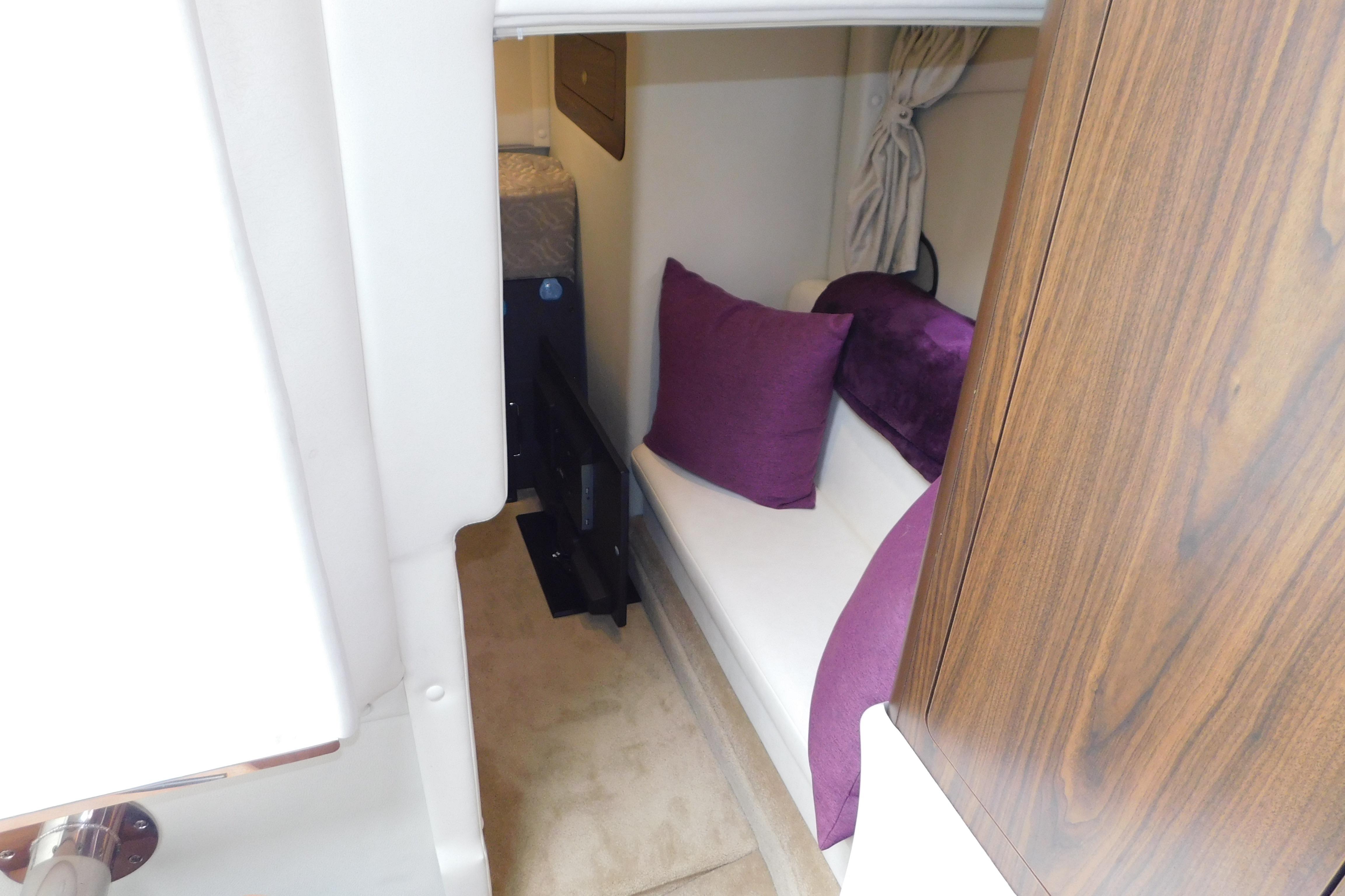 2017 Rinker EX 320 cabin interior with white seating and purple cushions.