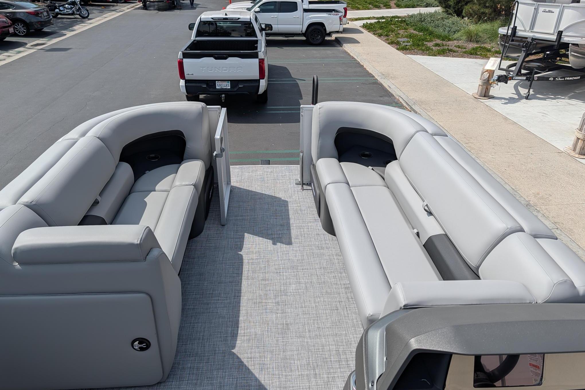 2026 Sun Tracker Party Barge 20 DLX with spacious seating in a parking lot.
