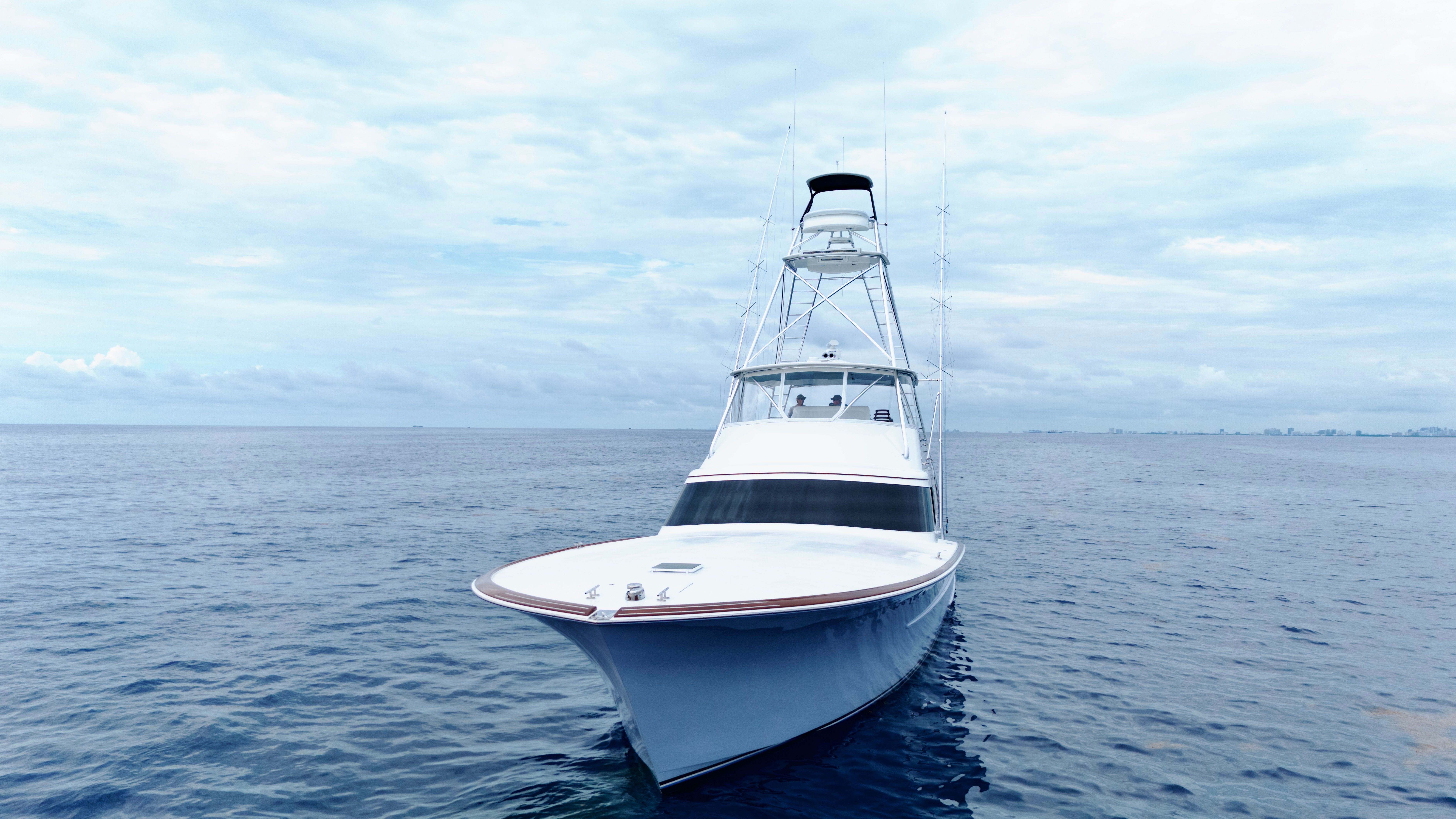 A 2025 Titan Yachts sportfish boat on calm water under a cloudy sky.