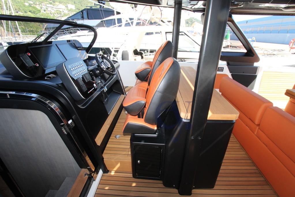 Interior of 2025 Cranchi A46 Luxury Tender with modern helm and orange seating.