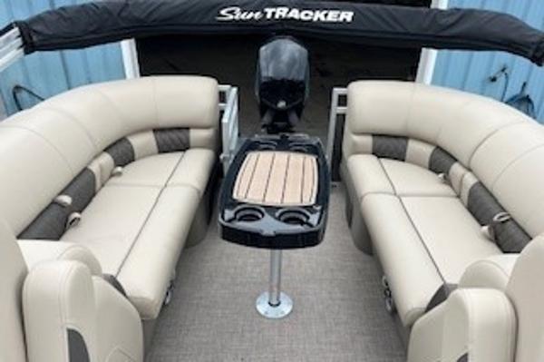 2024 Sun Tracker Party Barge 24 DLX interior with beige seating and central table.