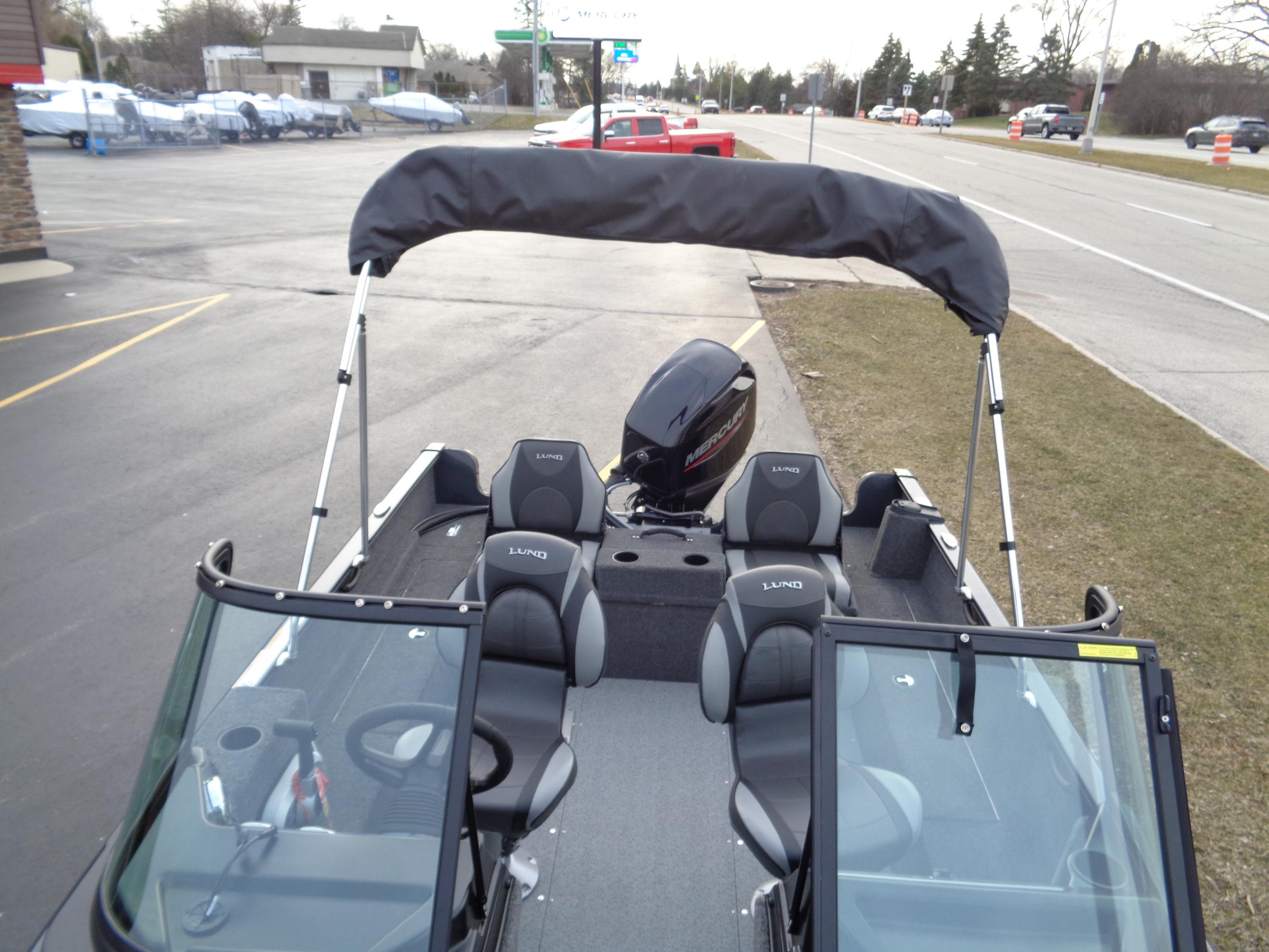 2024 Lund 1650 Rebel XL Sport boat with canopy and seating, parked outdoors.