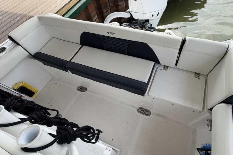 2024 Tidewater 232 LXF boat interior with cushioned seating and storage compartments.