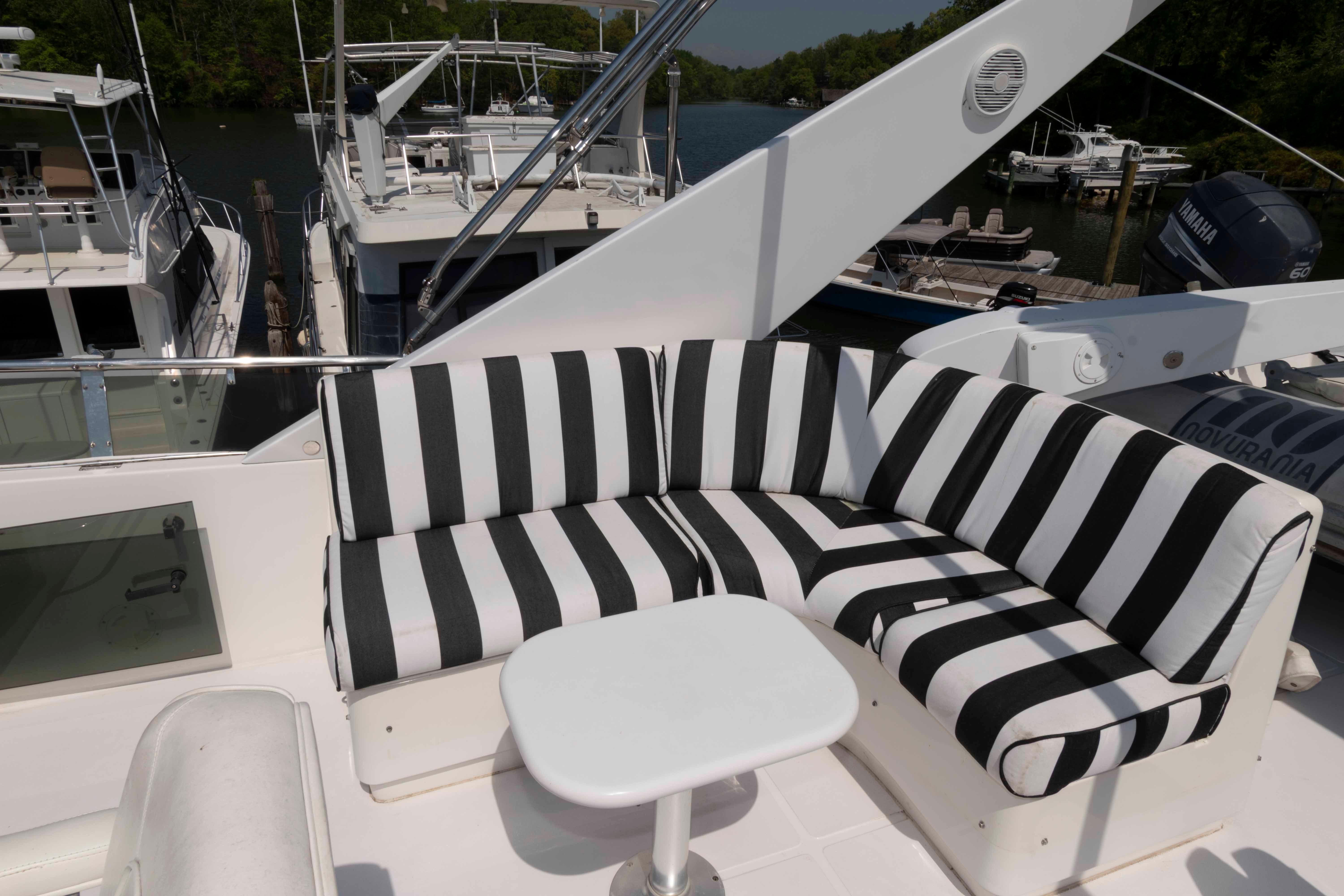 Luxurious 1999 West Bay 58 Sonship Pilothouse yacht with striped seating on deck.