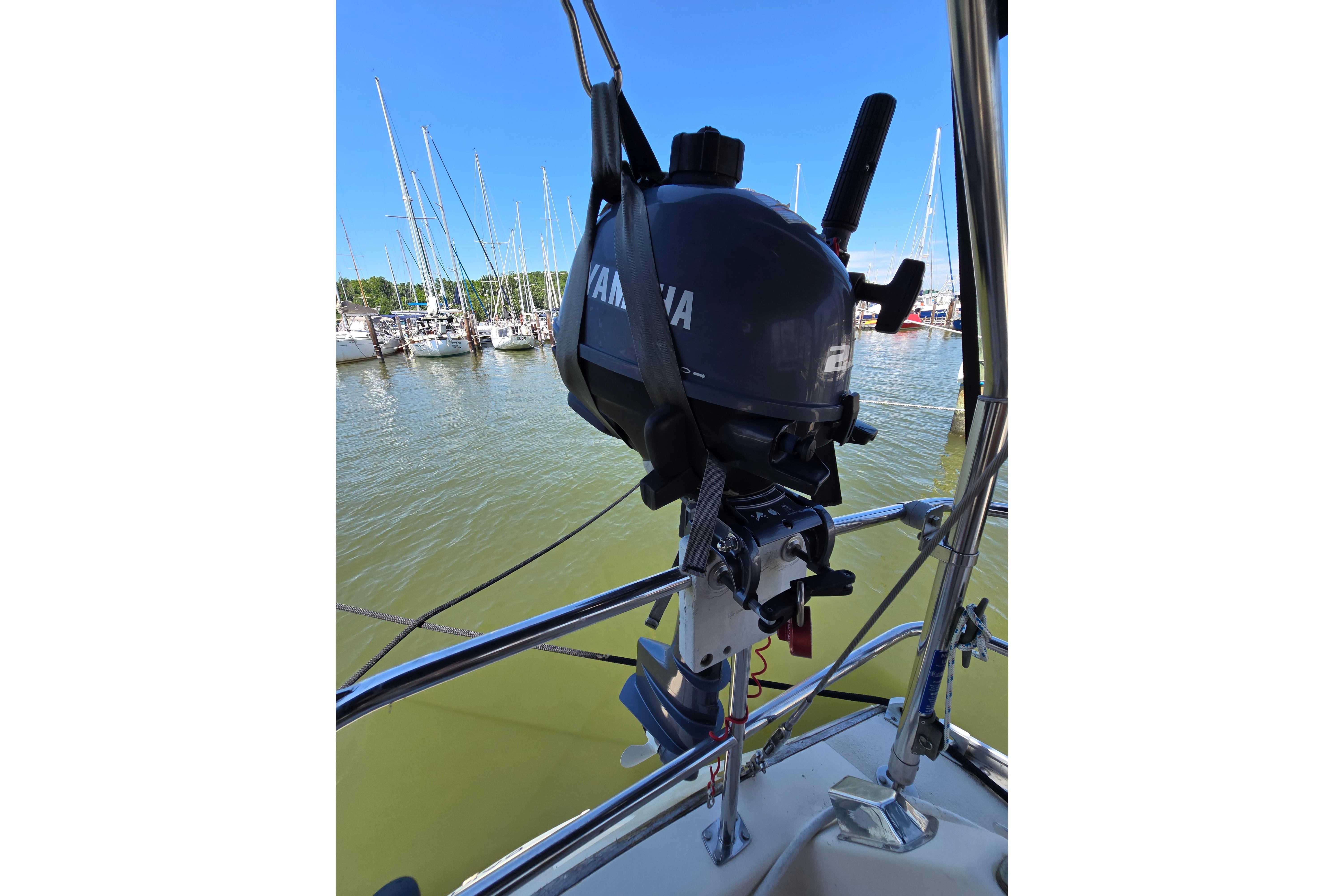 Outboard motor on a 1993 Caliber 35 sailboat, docked in a marina.