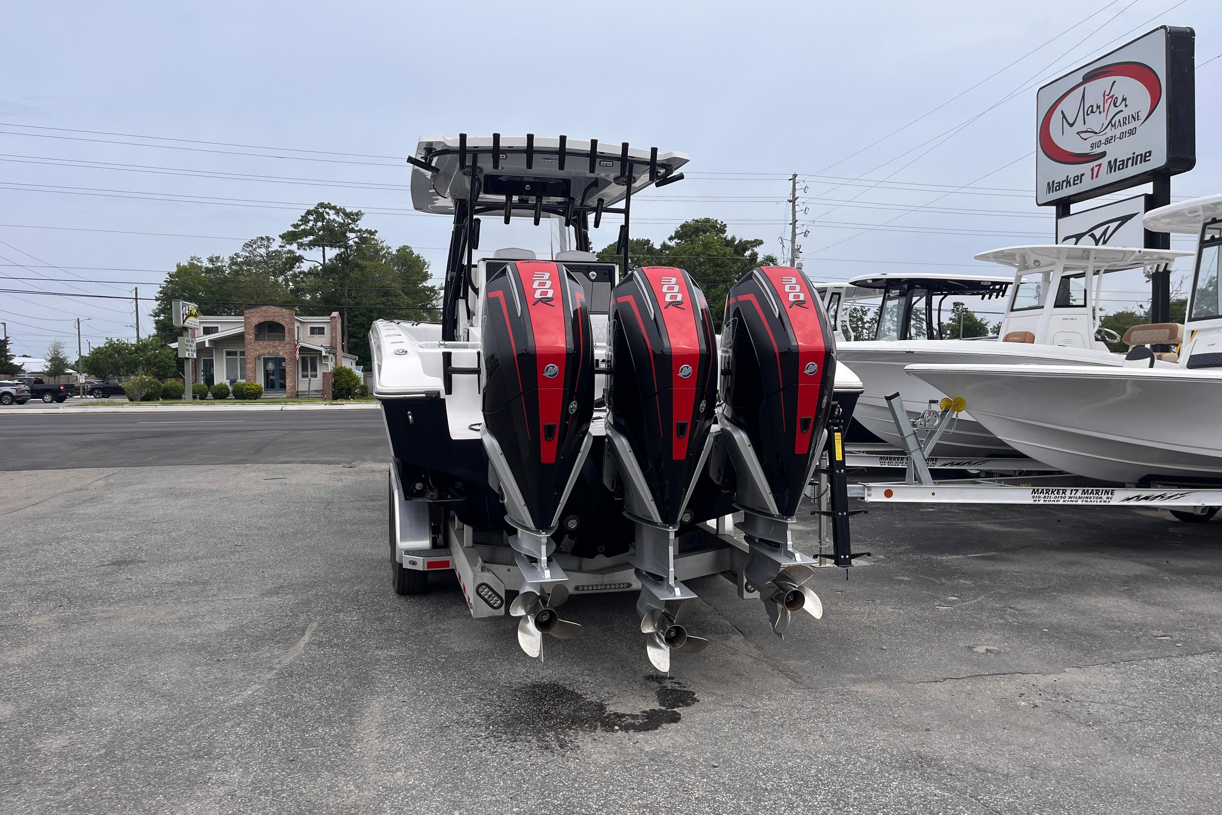 2024 Fountain 34 Tournament Edition boat with triple outboard engines at a marine dealership.