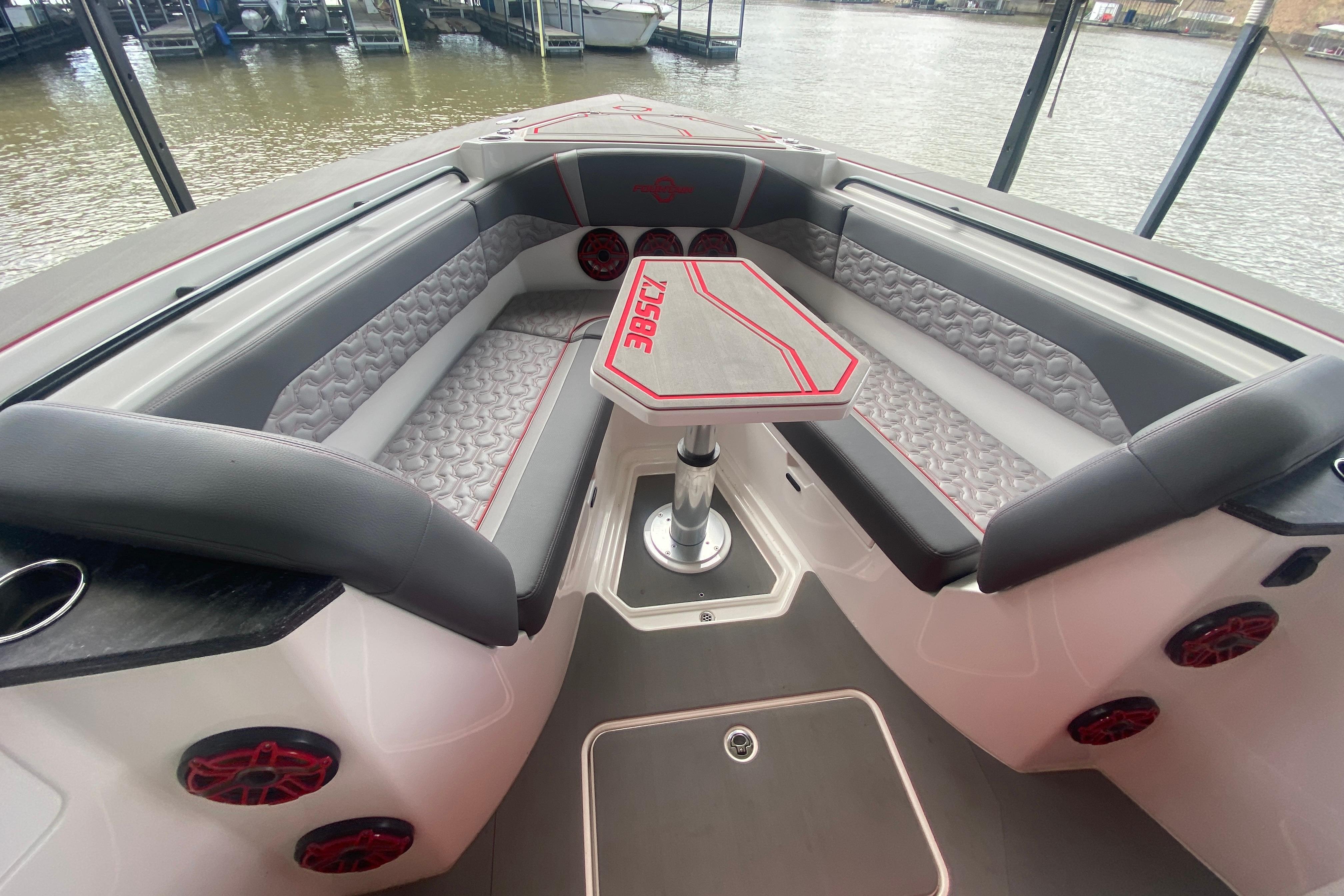 Luxurious seating area on 2025 Fountain 38 SCX boat with stylish upholstery and table.