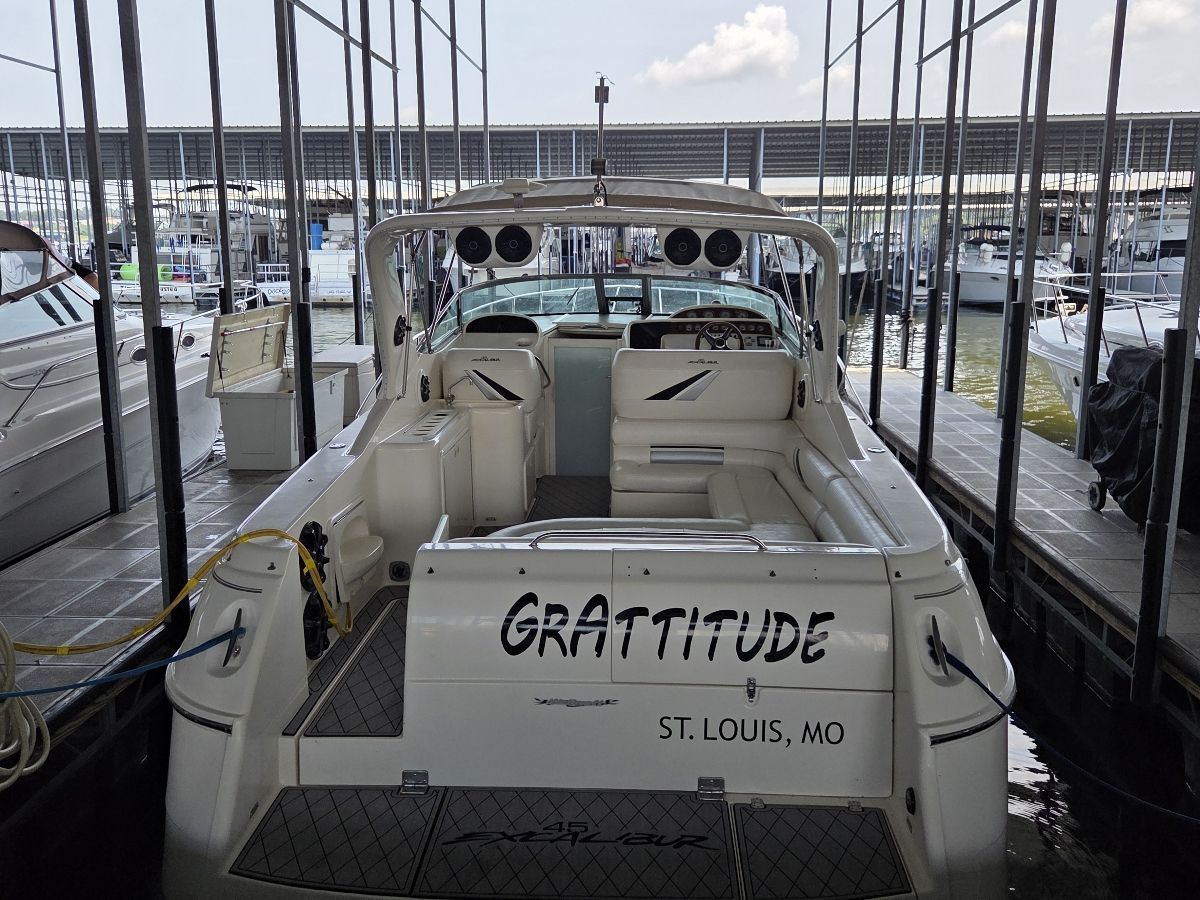 A 2000 Weldcraft Excalibur 45 docked in a covered marina. The name "GRATTITUDE" is visible on the stern.
