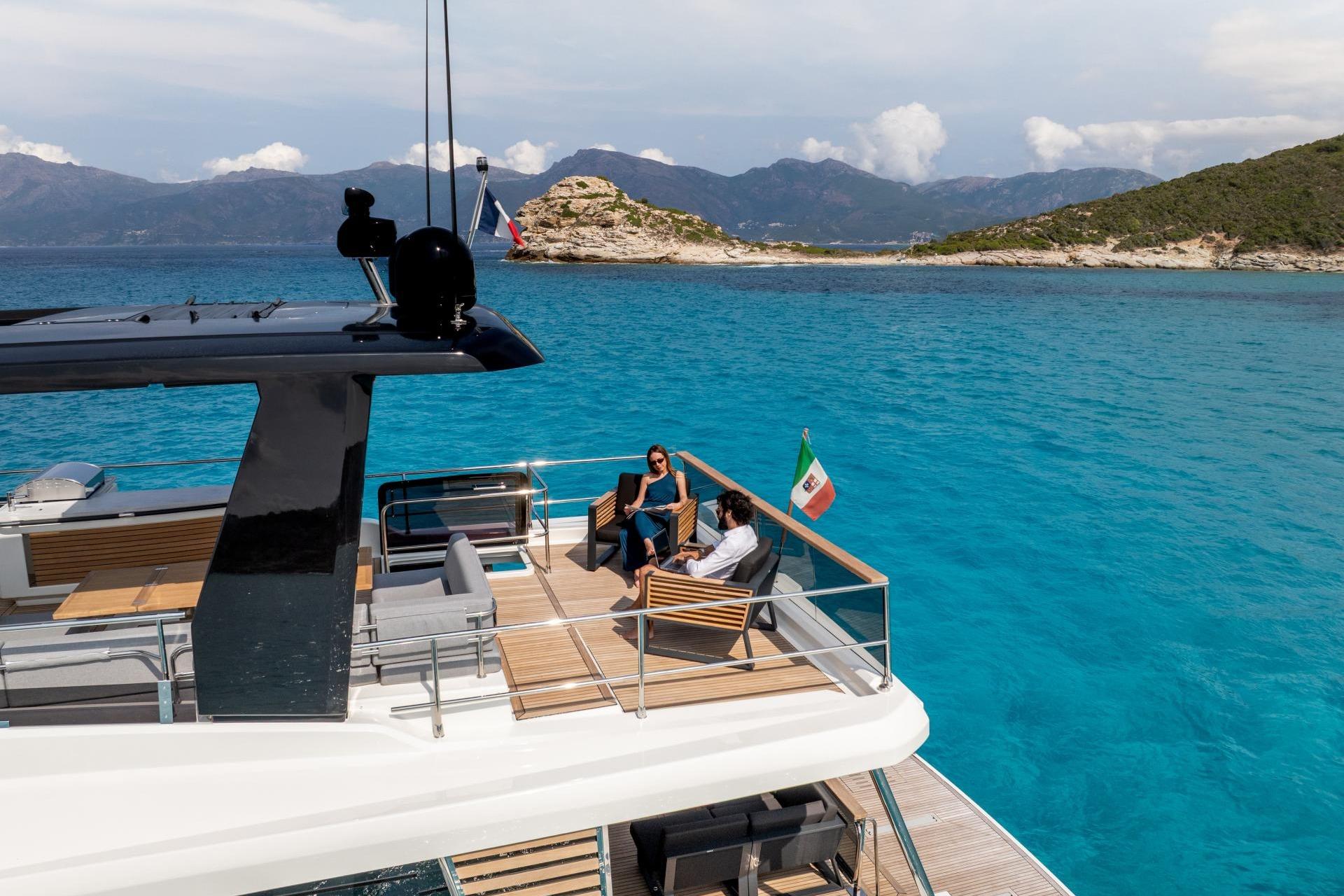 2026 Beneteau Grand Trawler 63 cruising in turquoise waters, with passengers relaxing on deck.