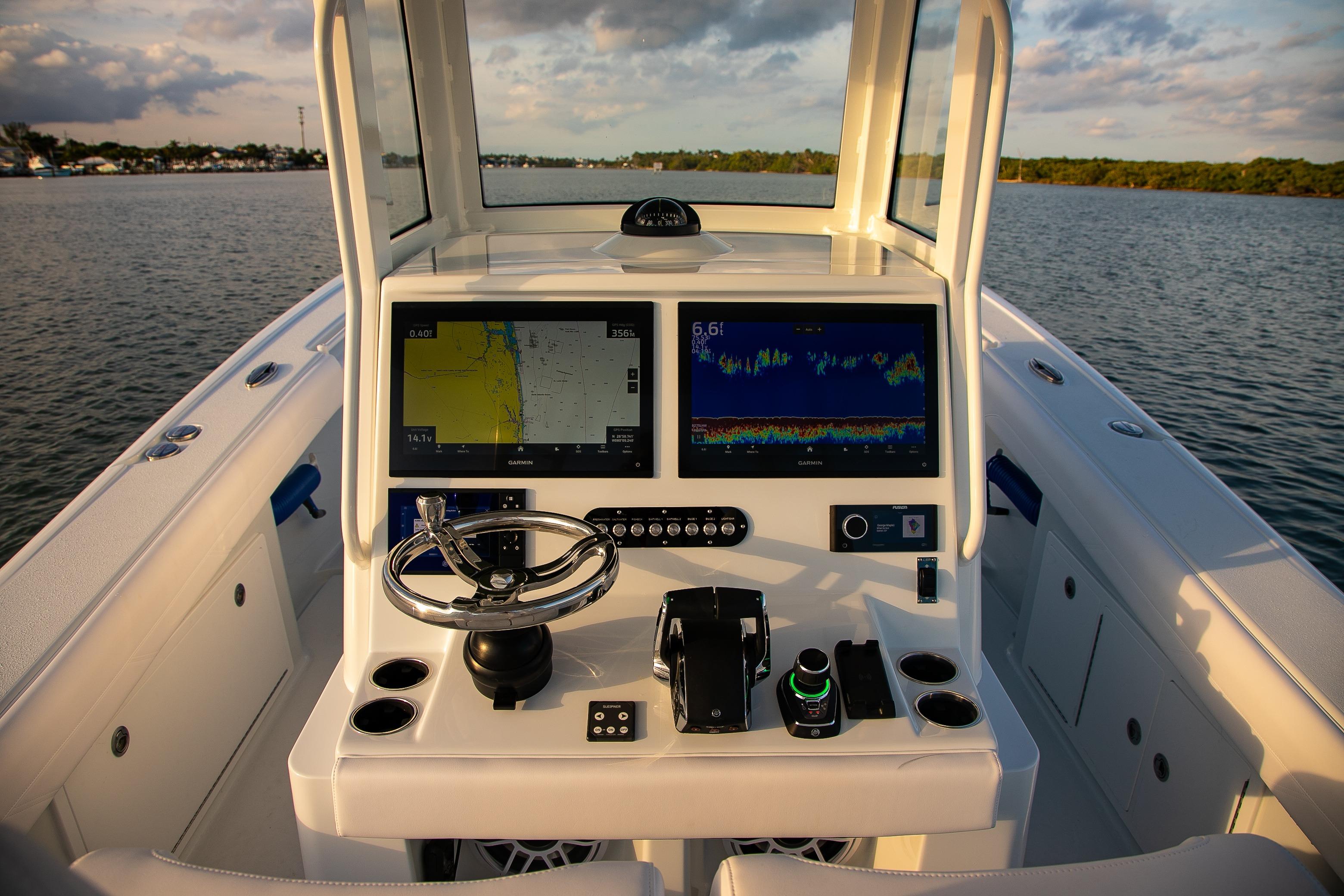 2026 Yellowfin 36 Offshore boat dashboard with dual navigation screens on calm water.