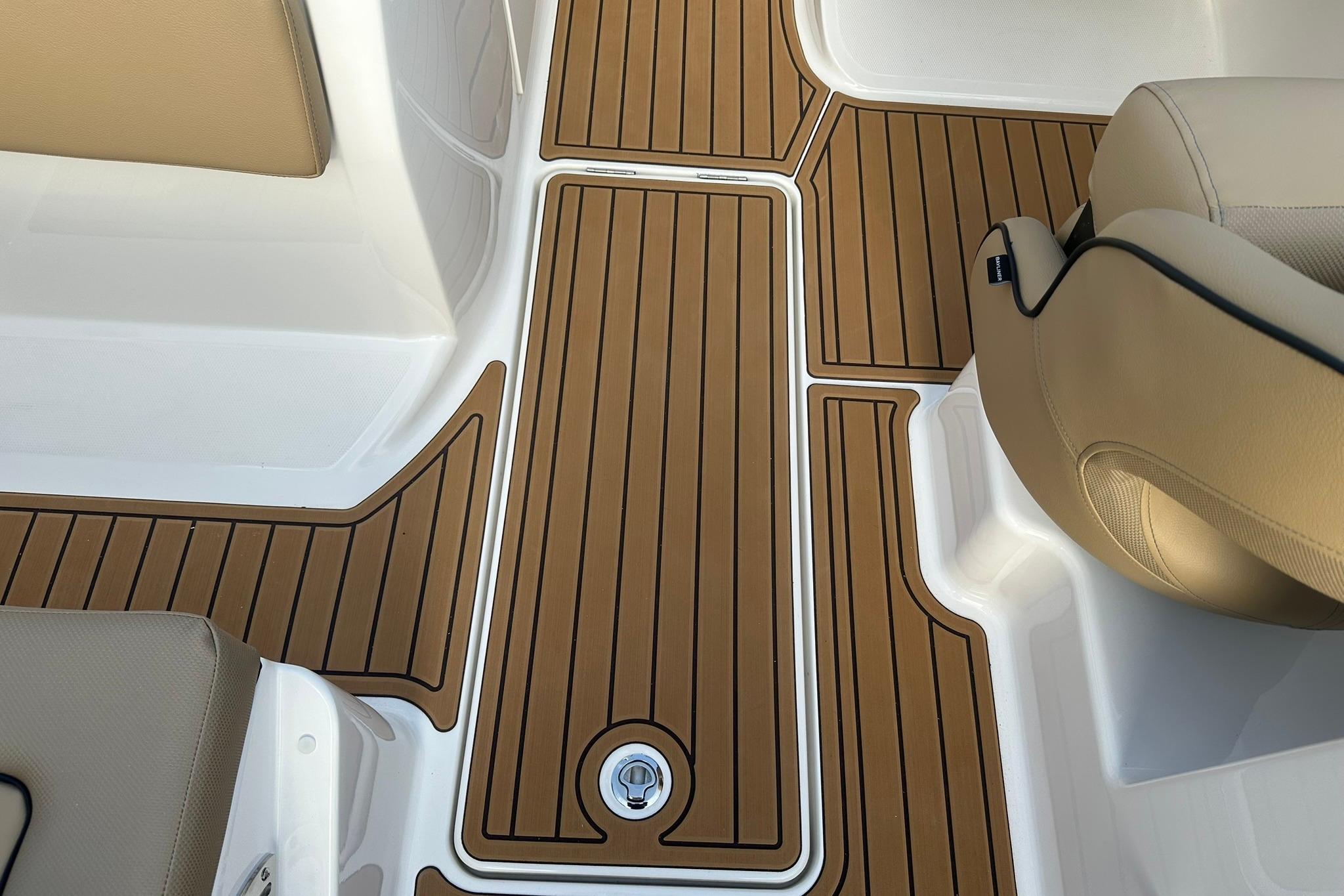 2026 Bayliner VR6 Bowrider OB interior with teak-style flooring and beige seating.