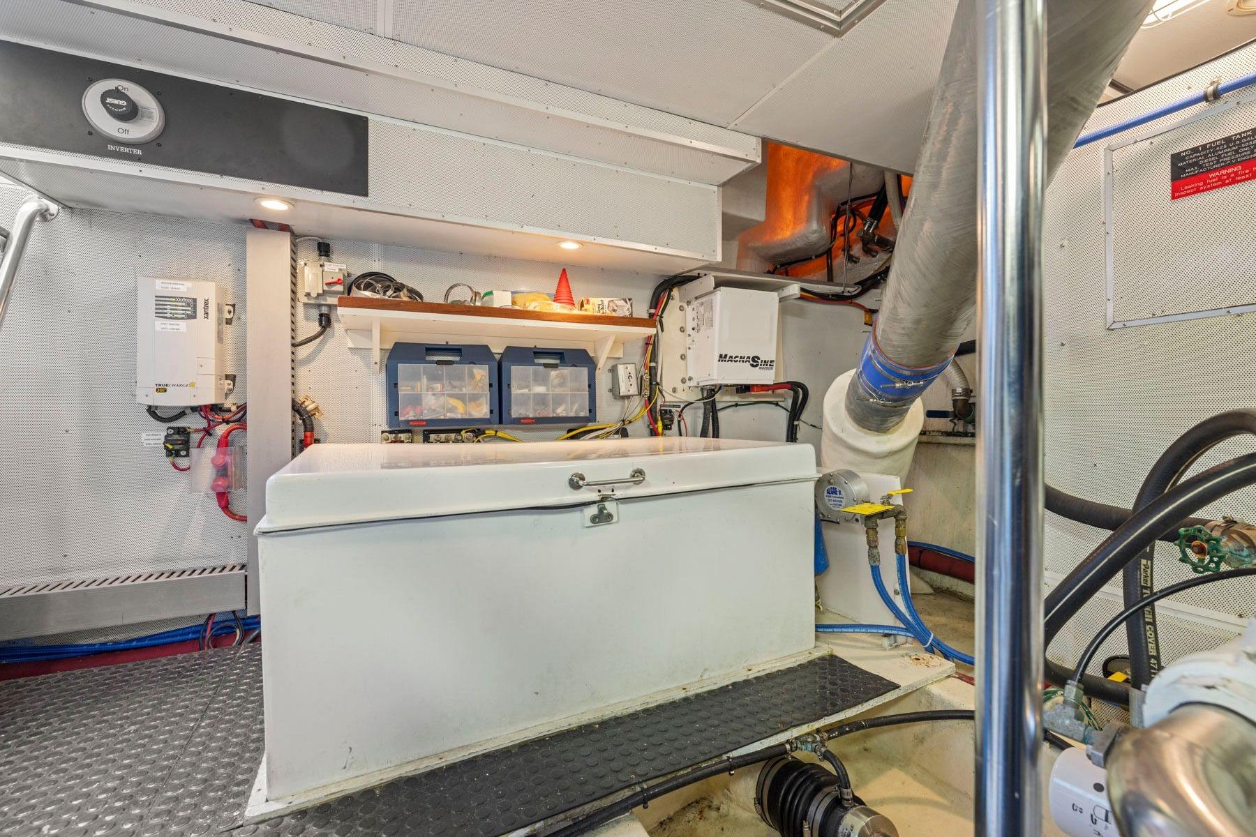 Engine room of a 1999 Symbol 55 yacht, featuring equipment and storage.