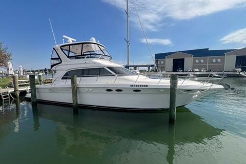 2001 Sea Ray 480 Sedan Bridge yacht docked at marina under clear blue sky.