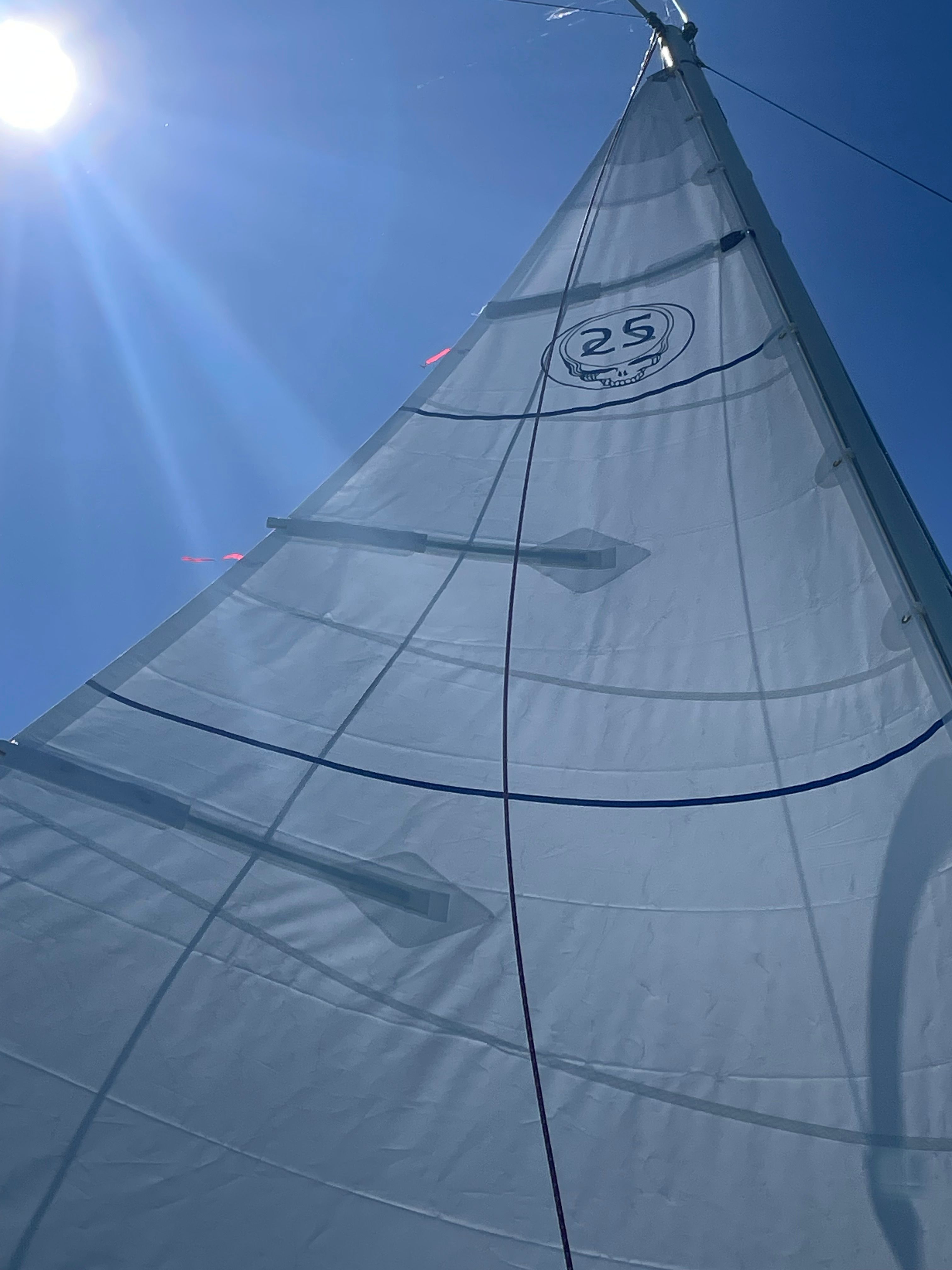 1984 O'Day 25 sailboat under clear blue sky.