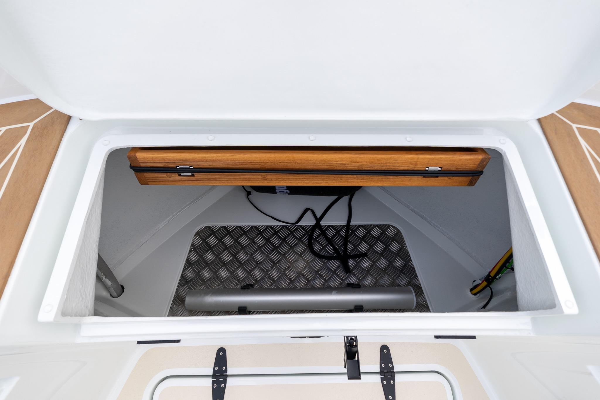 Storage compartment of 2026 Targa 27.2 boat with wooden accents and metal flooring.