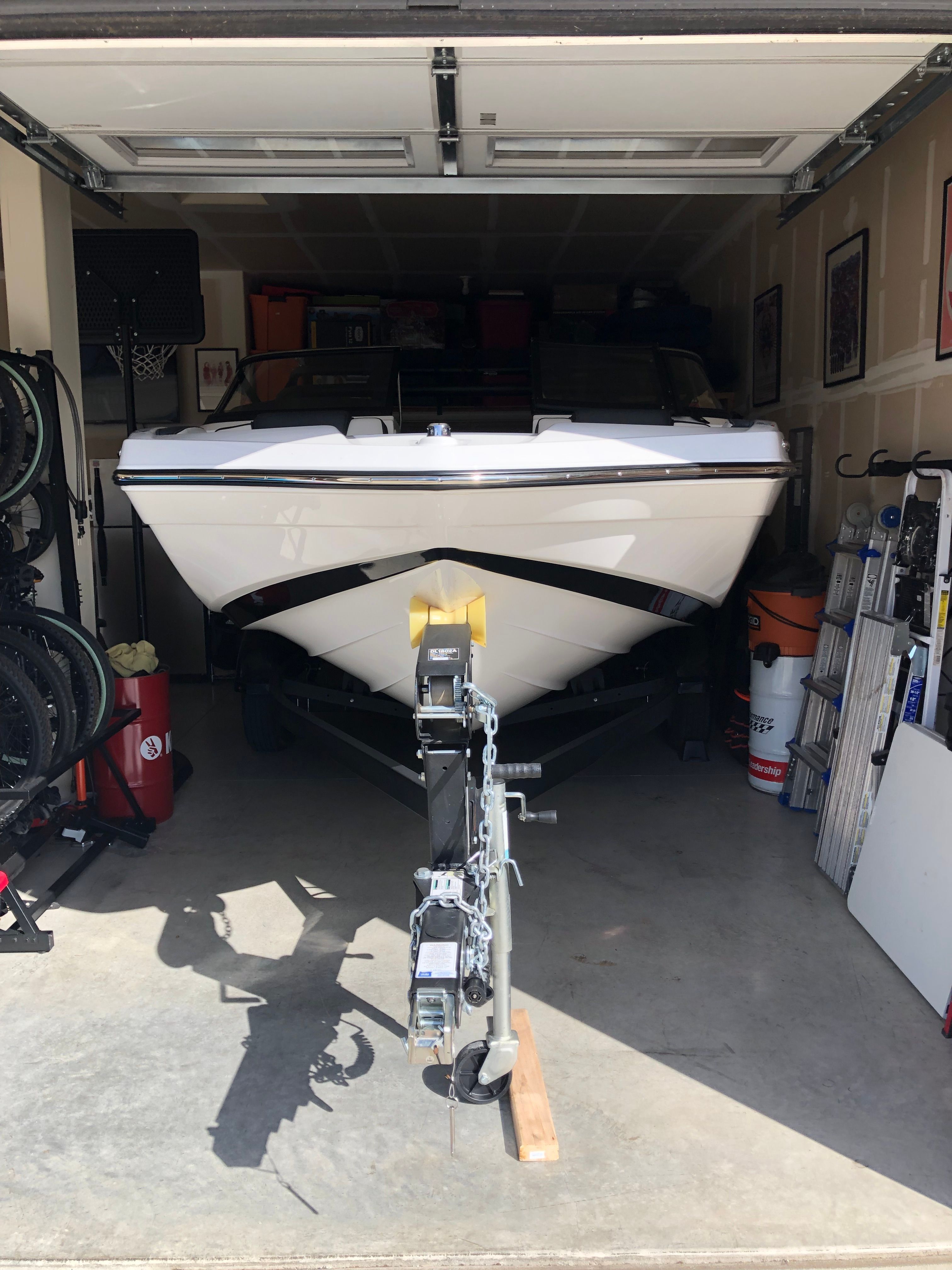 A Yamaha AR195 boat is parked in a garage on a trailer.