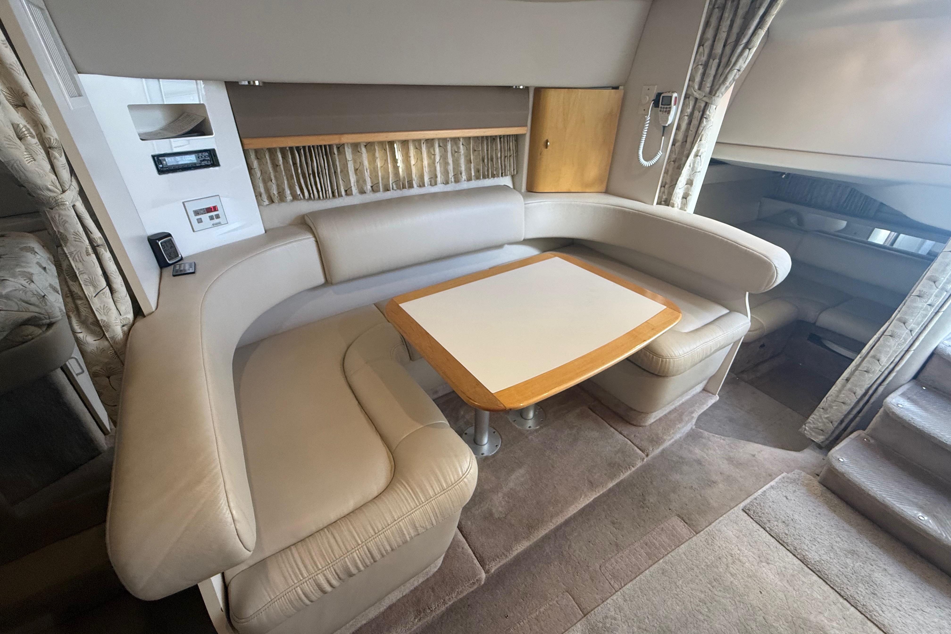1999 Formula 34 Performance Cruiser interior with beige seating and wooden table.