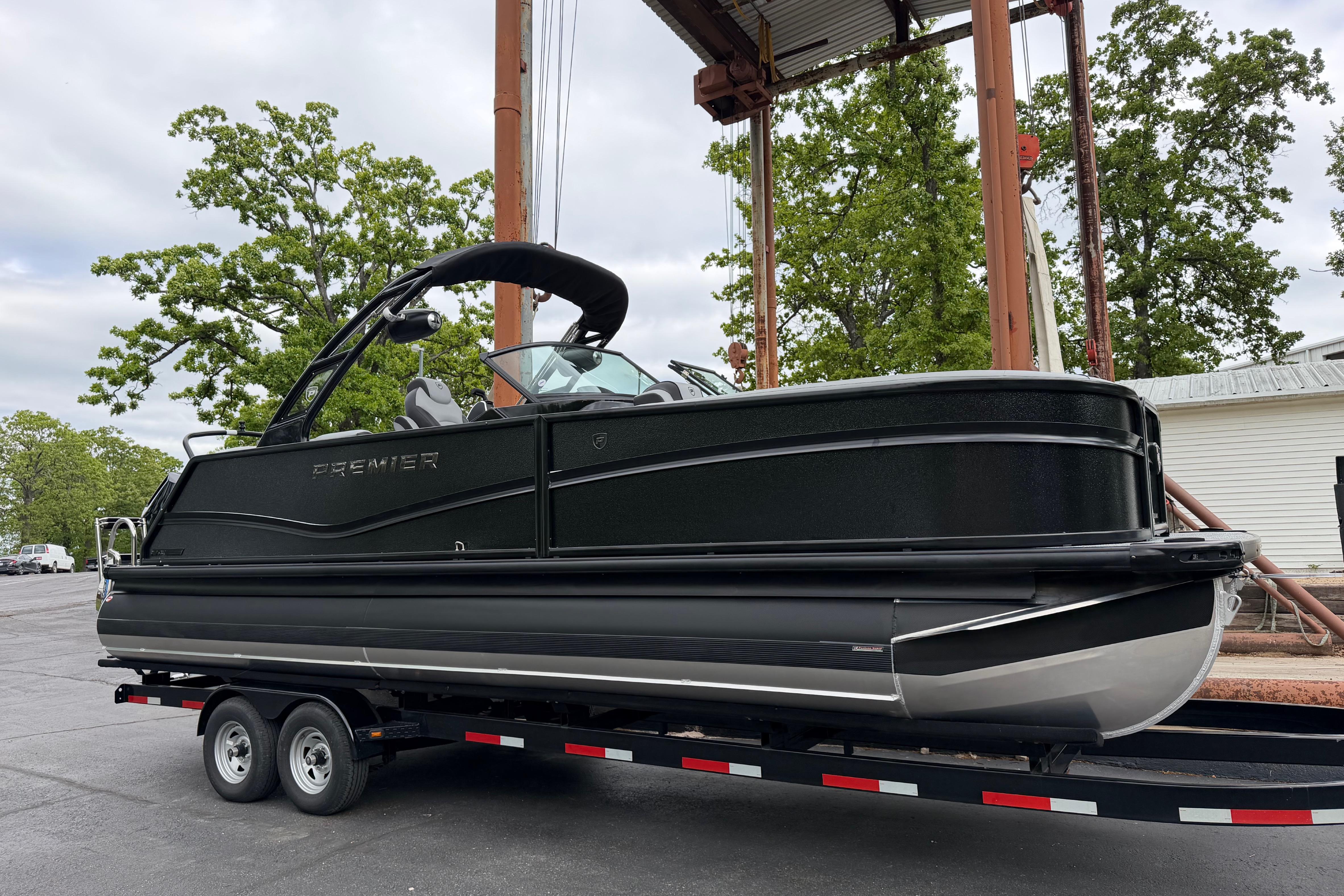 2026 Premier 250 Solaris Sport pontoon boat on trailer, parked outdoors.