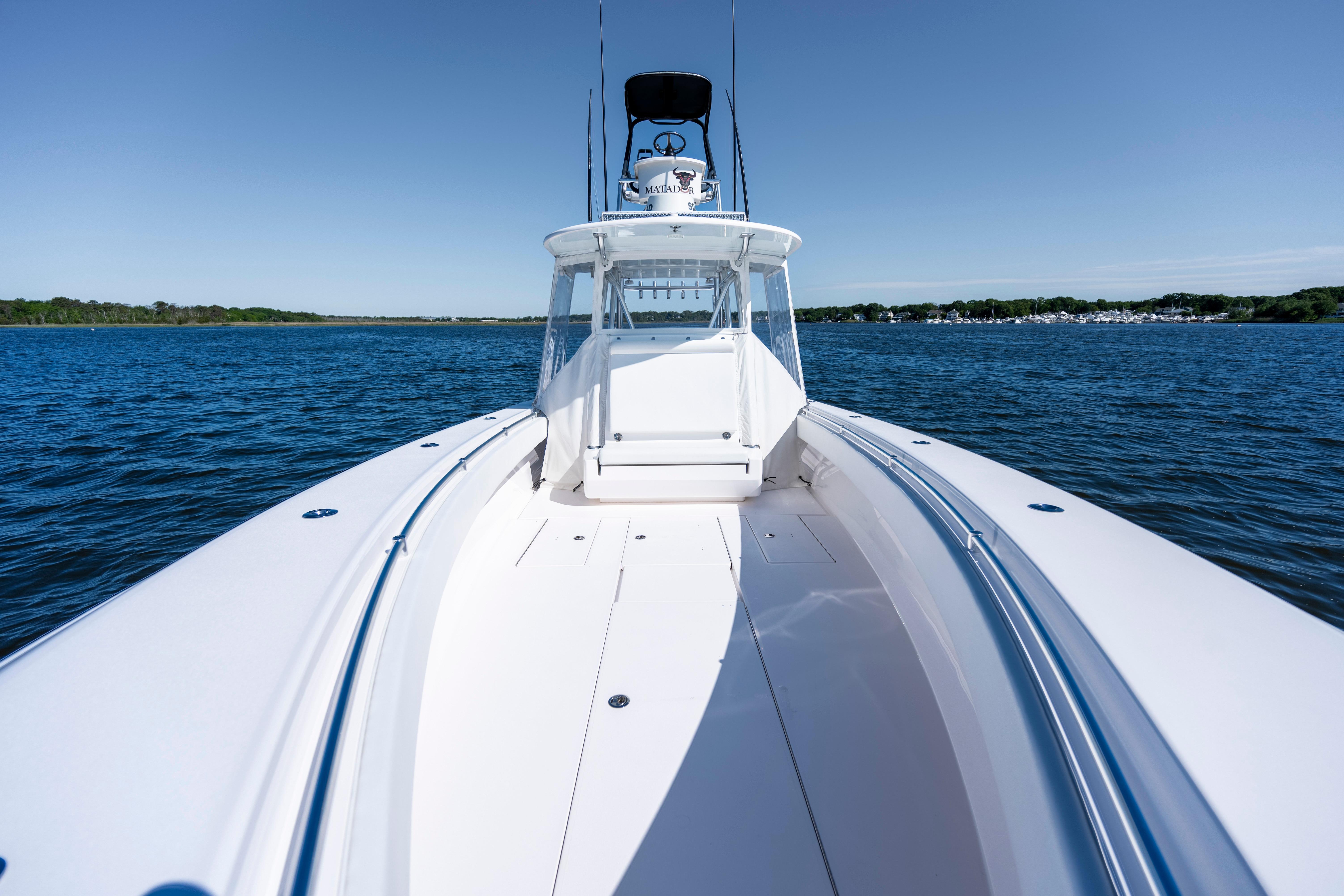 2015 Contender 39 ST boat on open water, clear sky, and distant shoreline.