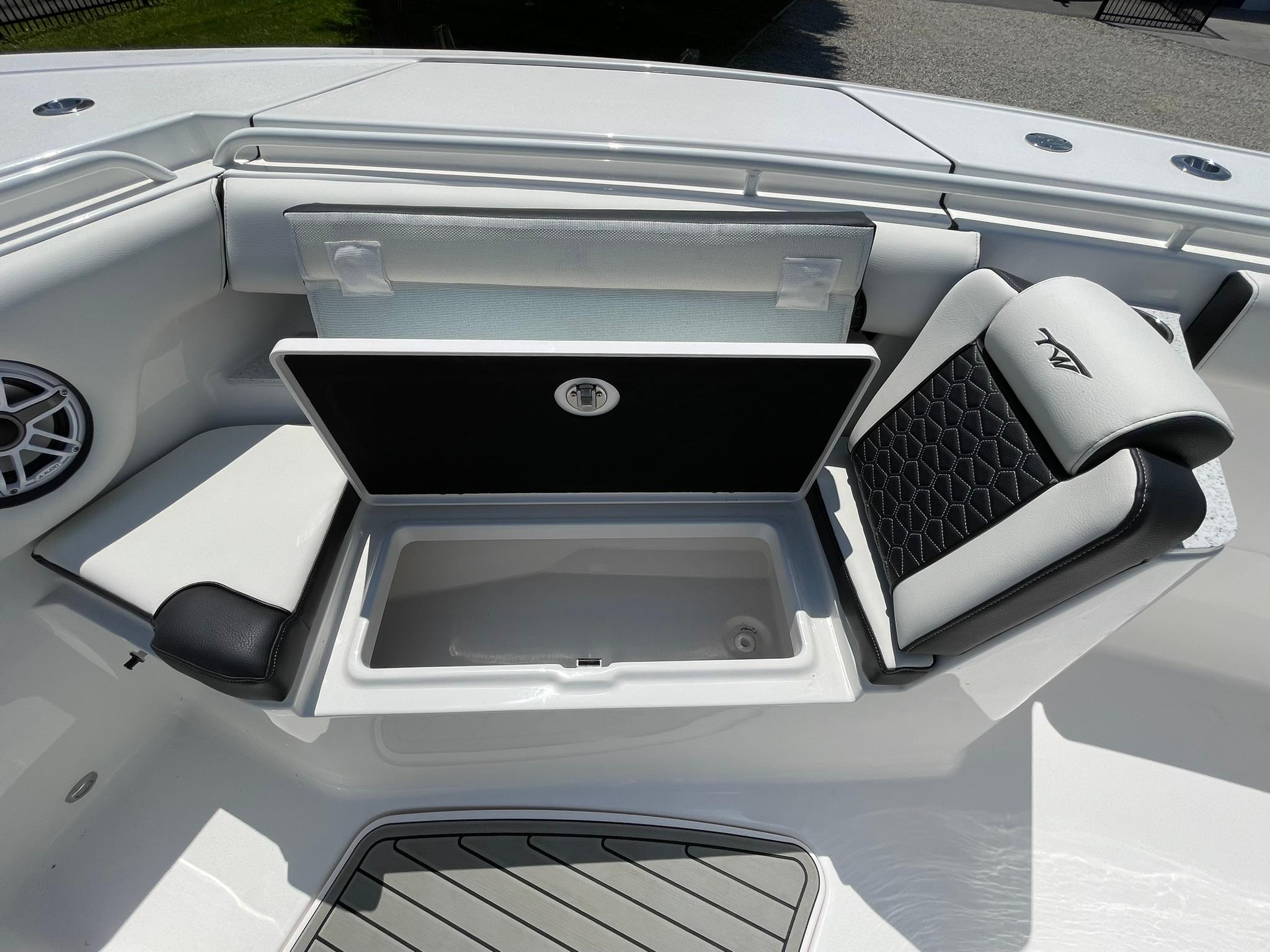 2026 Tidewater 302 CC Adventure boat interior with open storage compartment and cushioned seating.