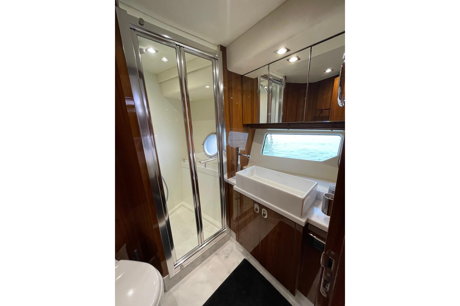 Luxurious bathroom in 2016 Sunseeker Manhattan 65 yacht with modern fixtures and ocean view.