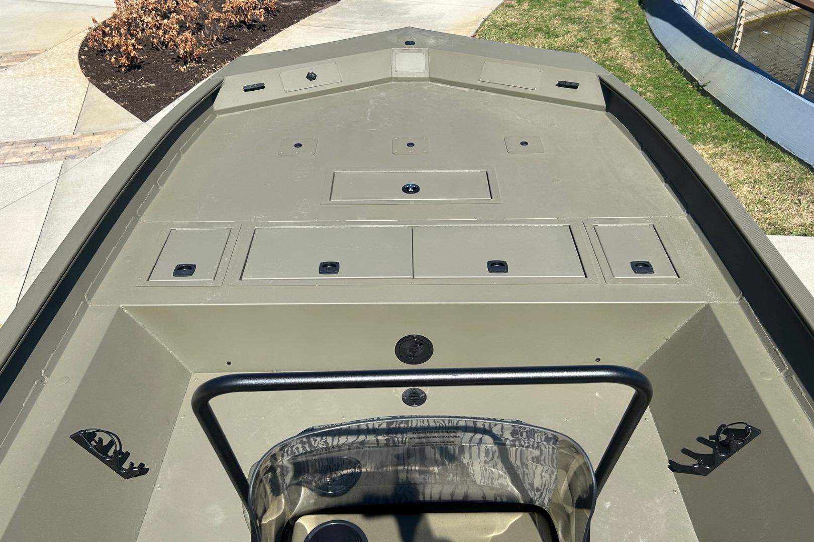 2026 Tracker Grizzly 2072 CC boat deck with storage compartments, outdoors.