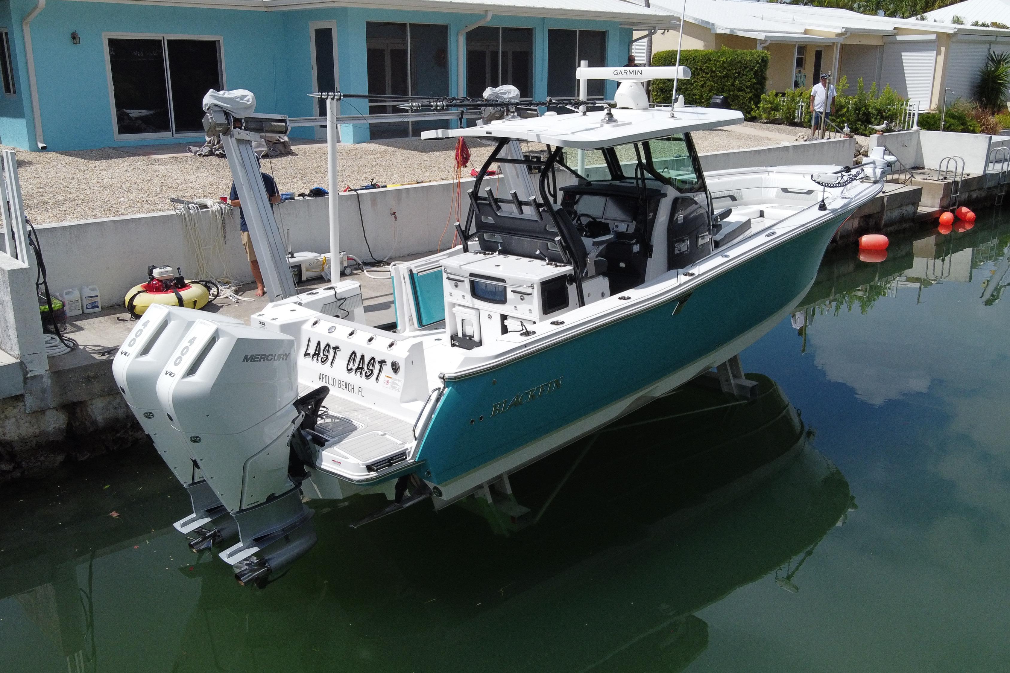 2024 Blackfin 332 CC boat docked, featuring twin Mercury engines and modern design.