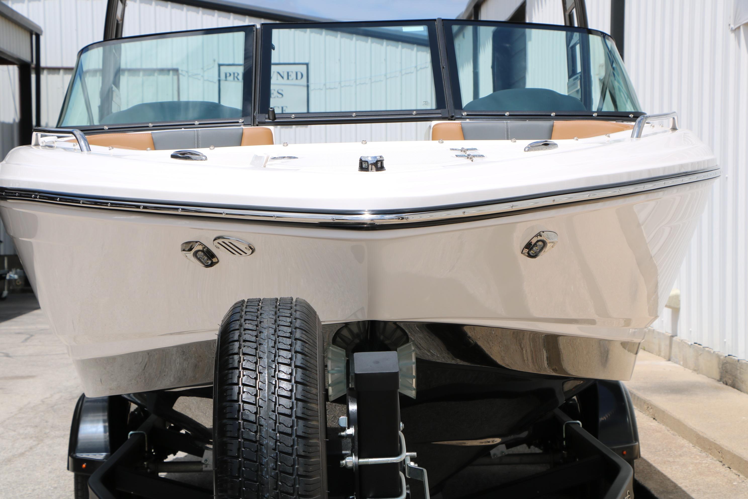 2025 Chaparral 23 SSi boat on trailer, front view, in a marina setting.