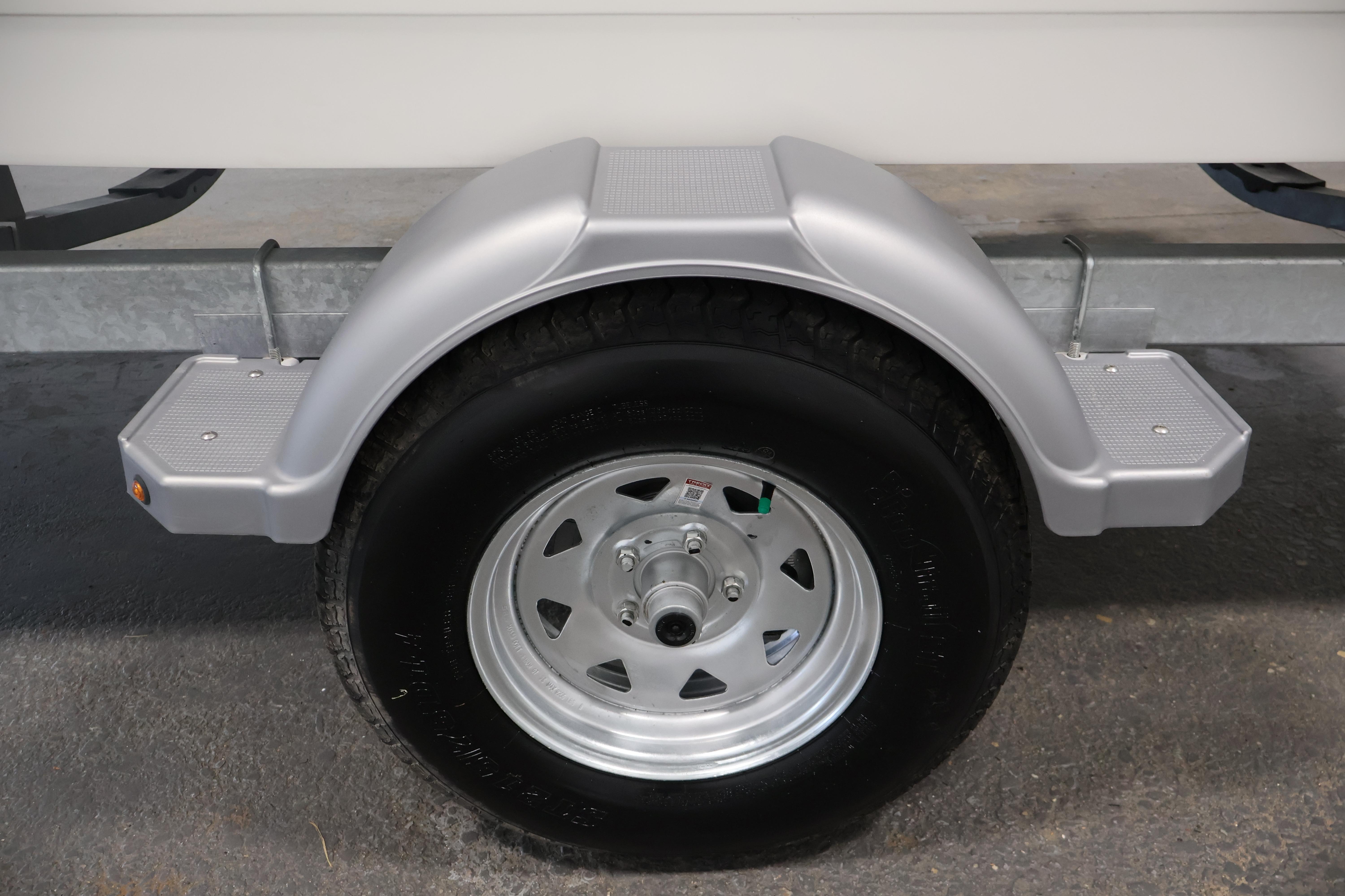 Trailer wheel of 2026 Bayliner Trophy T18 boat, featuring a silver fender and step.