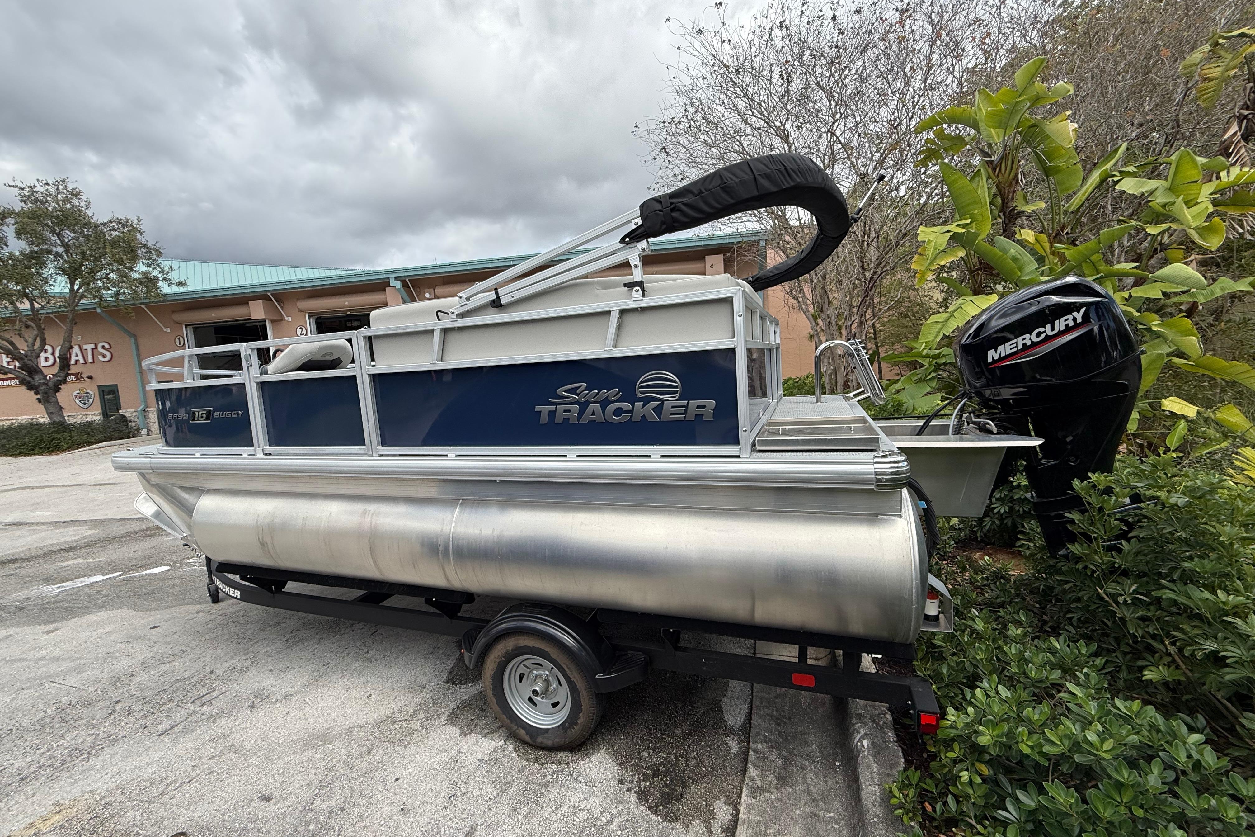 2026 Sun Tracker Bass Buggy 16 XL Select pontoon boat with Mercury outboard motor.