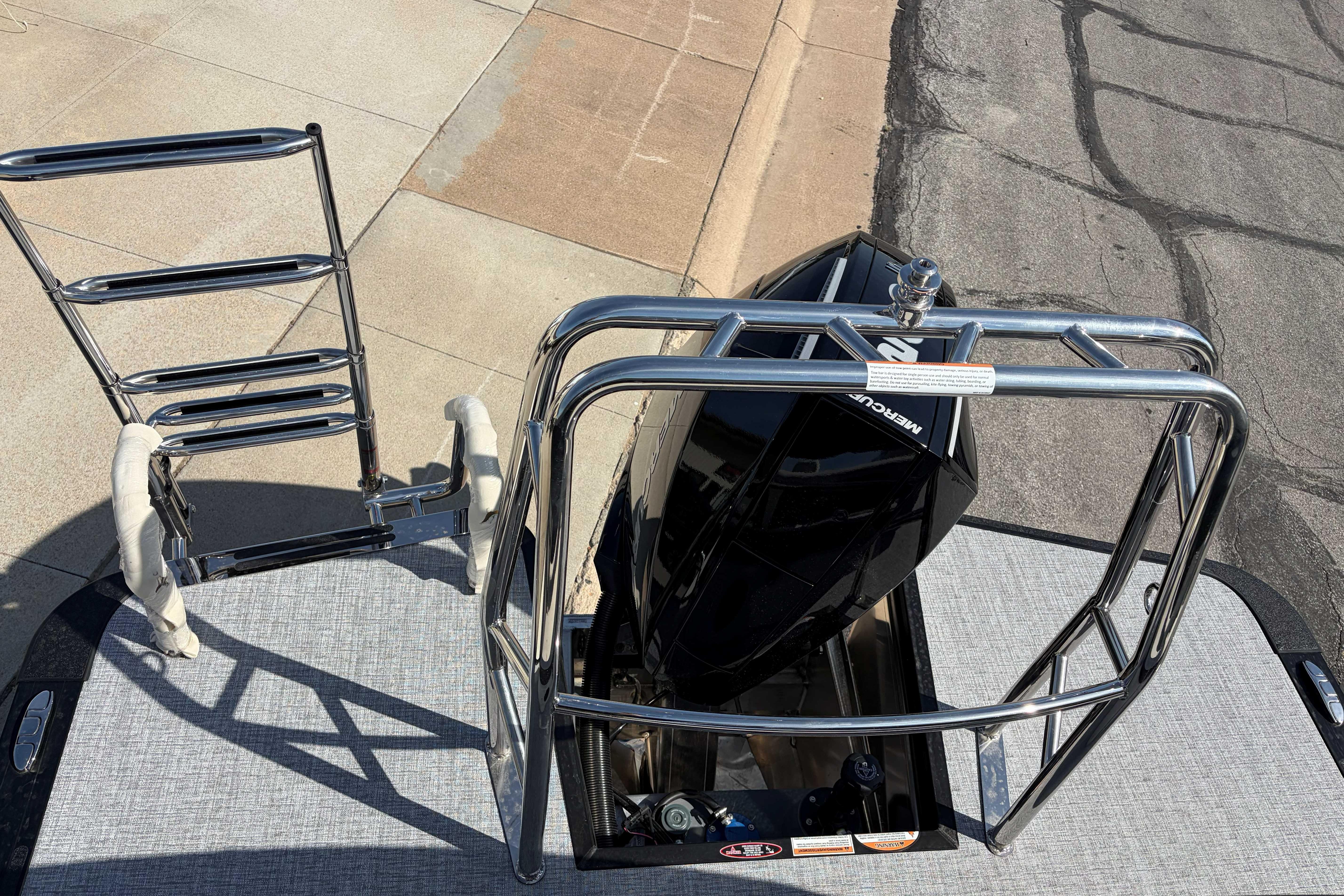 2025 Harris Cruiser 250 boat with ladder and Mercury engine.