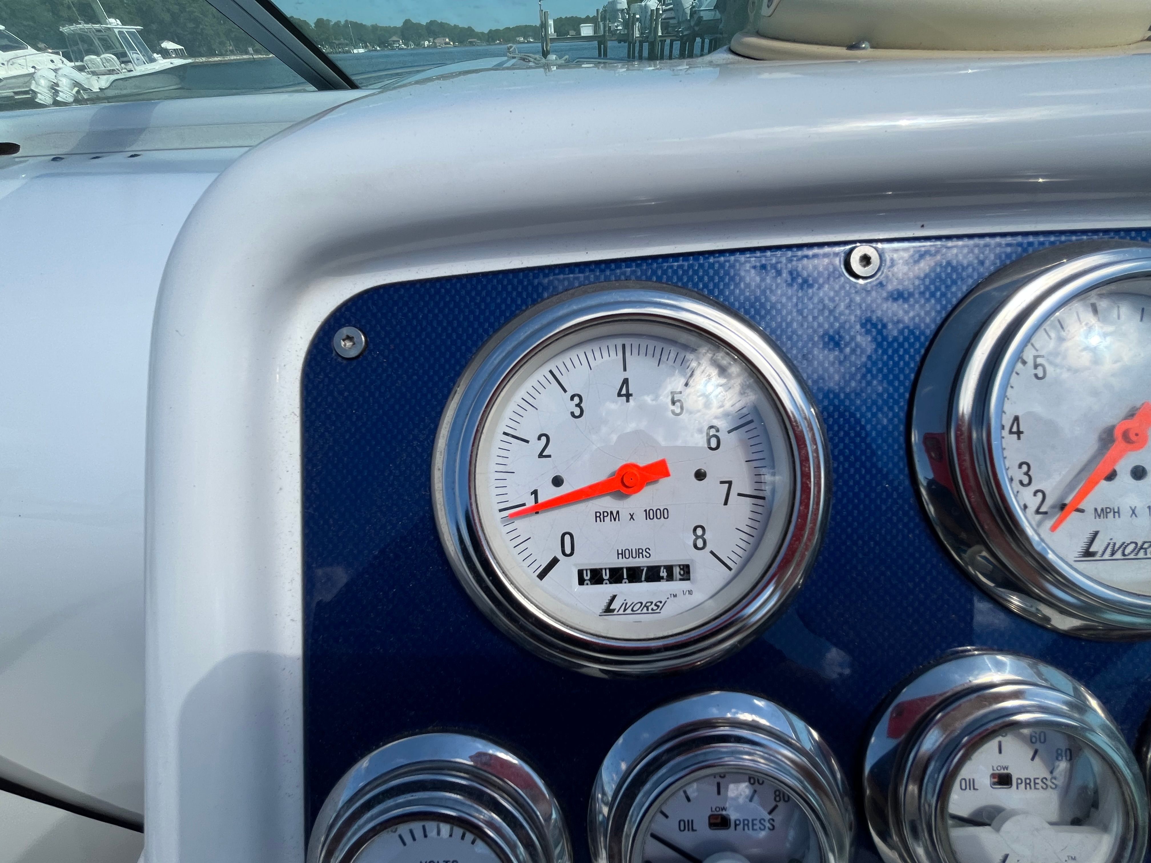 Close-up of boat instruments with tachometer and oil pressure gauges.