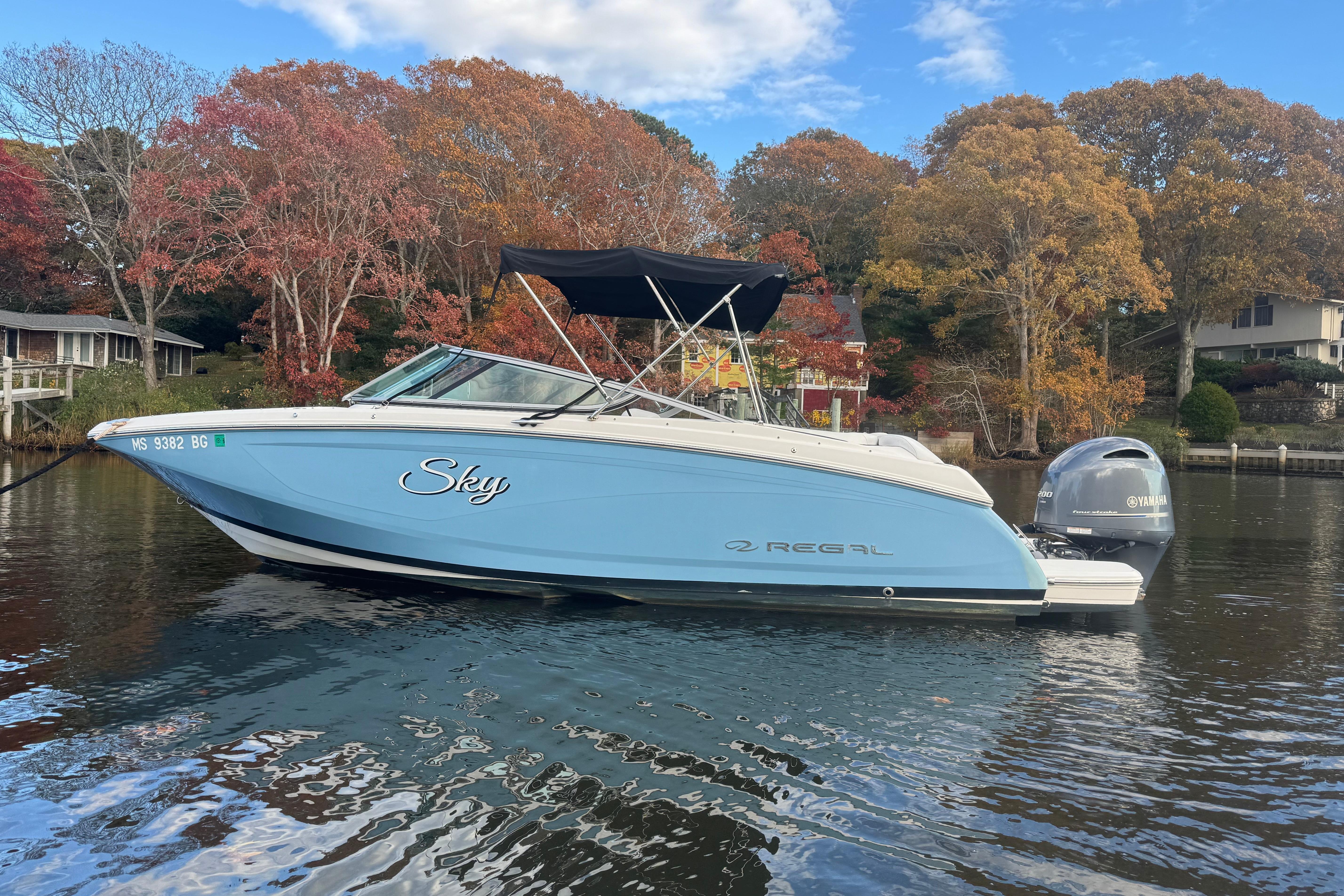 2017 Regal 23 OBX boat on calm water, surrounded by autumn trees.