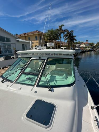 2006 Tiara Yachts 3200 Open docked near waterfront homes under clear skies.