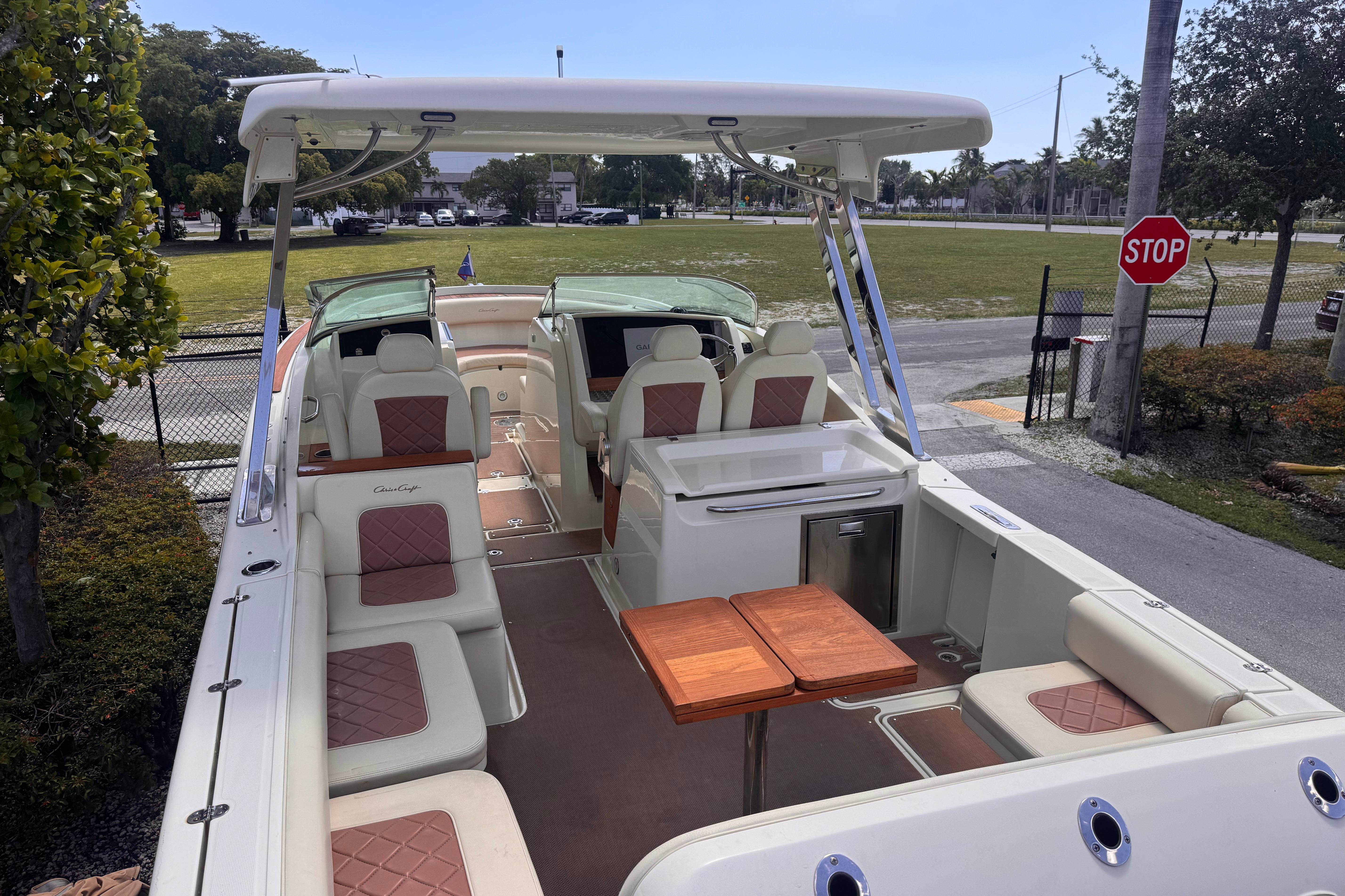 2018 Chris-Craft Calypso 30 boat interior with seating and wooden table.