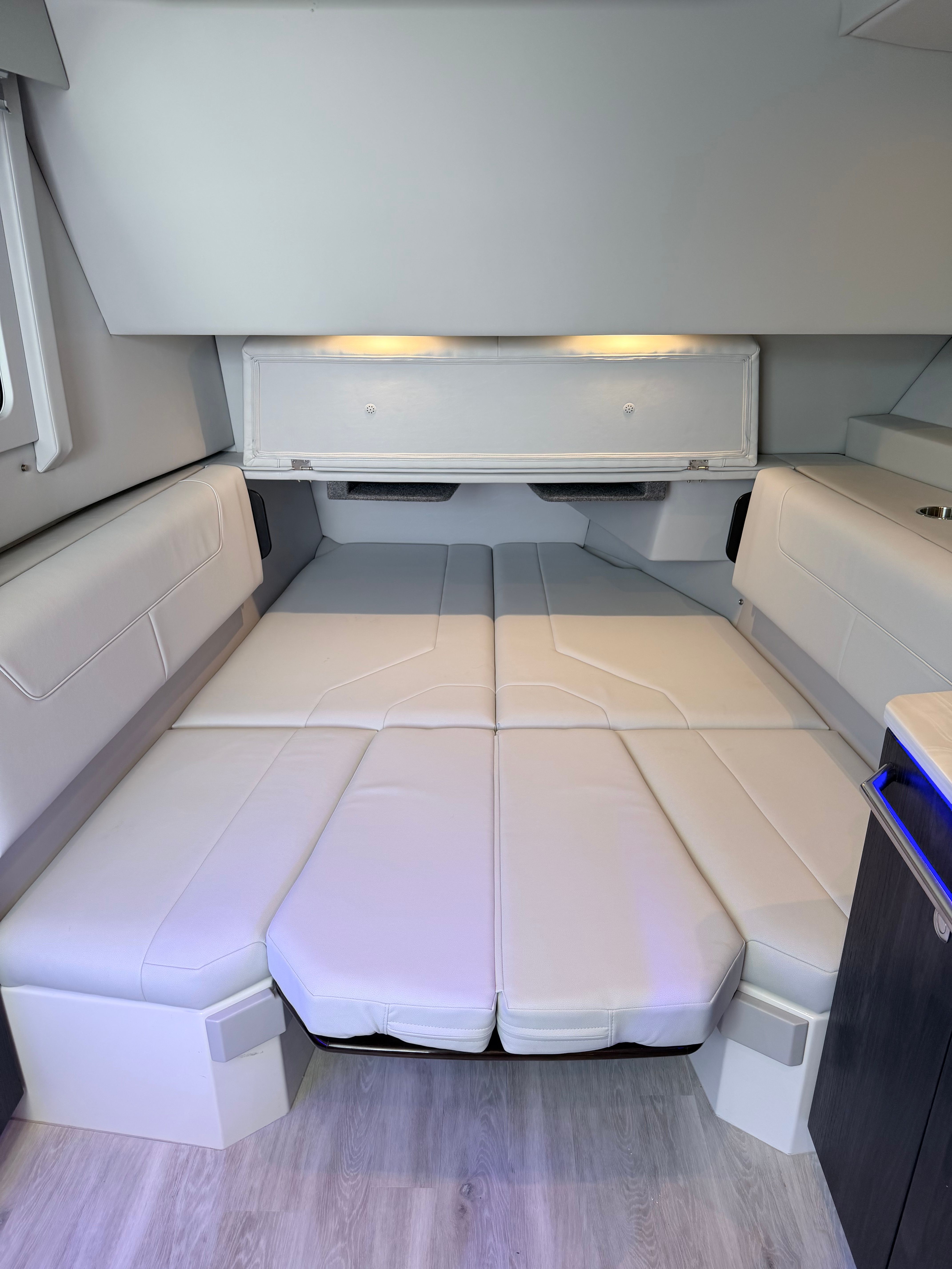 Interior of a 2023 Formula 400 Super Sport Crossover with white upholstery and wood flooring.
