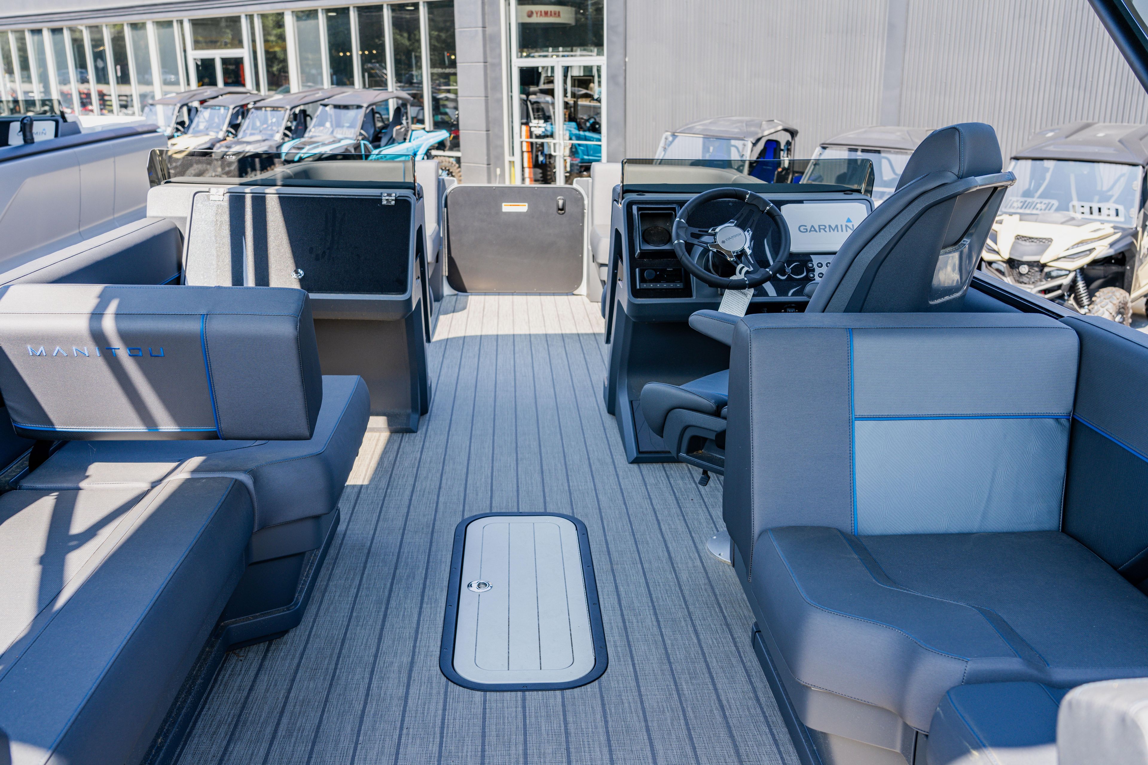 2023 Manitou 24 EXPLORE SWITCHBACK boat interior with seating and steering console.