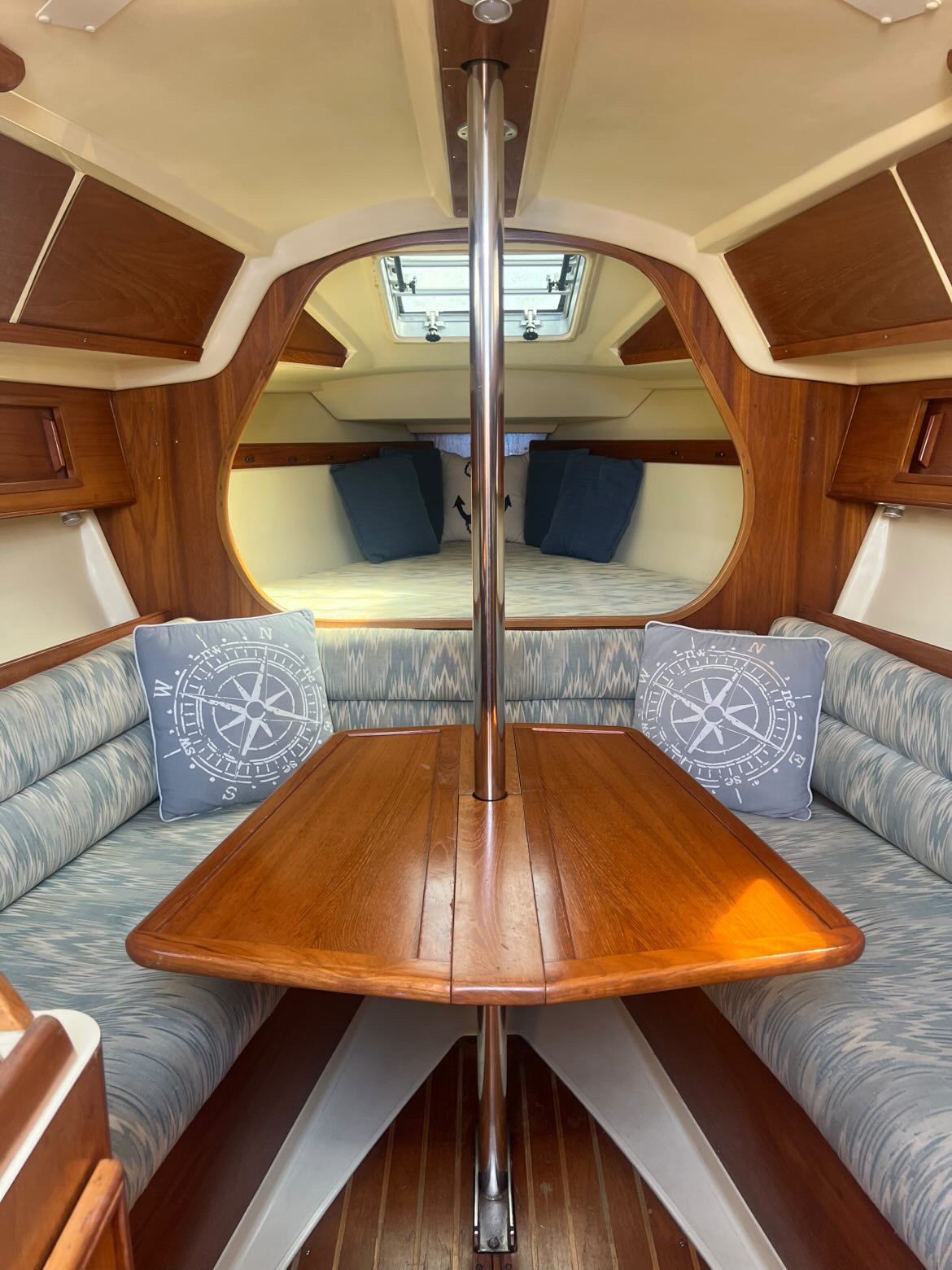 Interior of a 1988 Pearson 28 sailboat with a wooden table and cushioned seating.