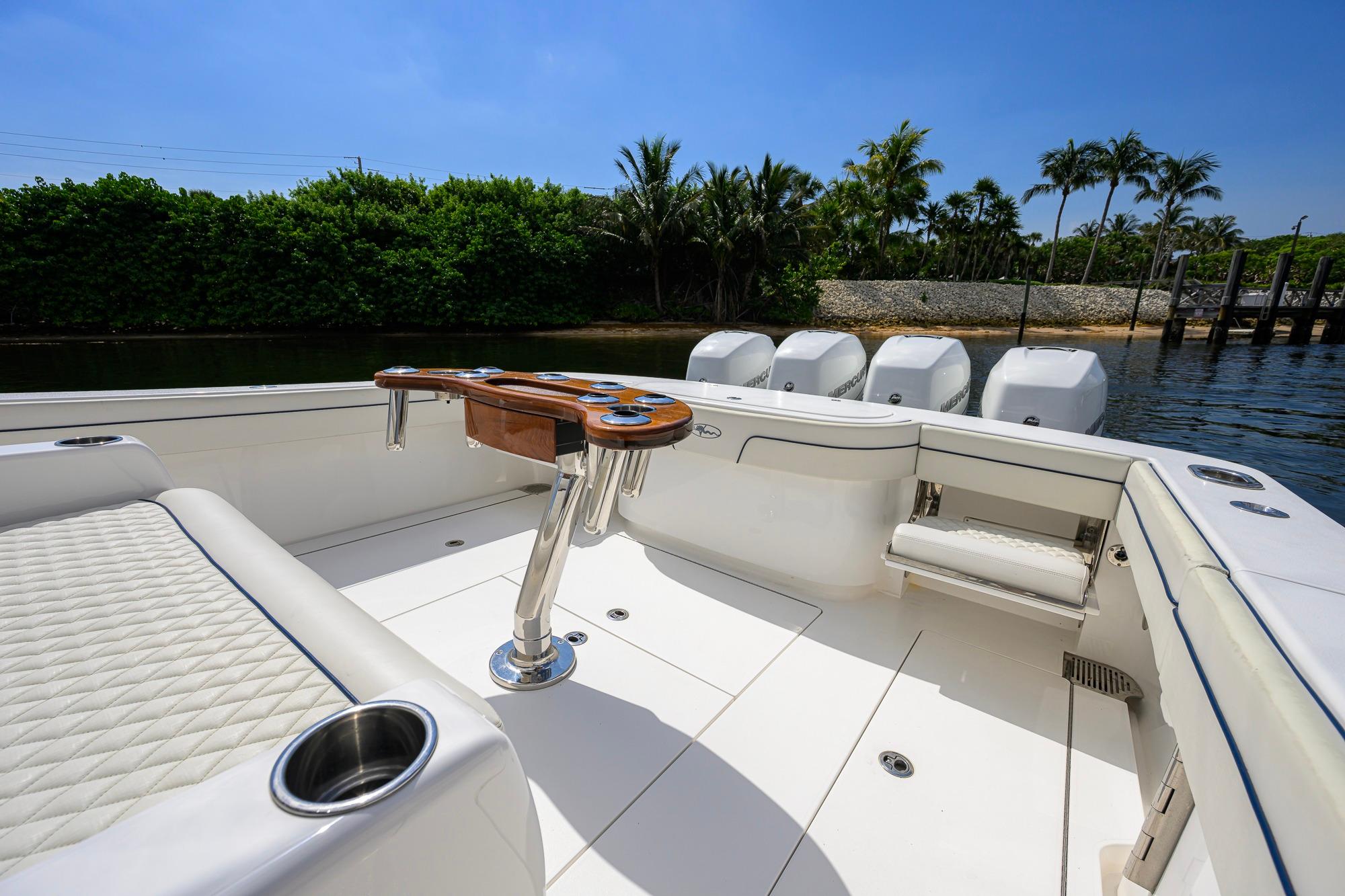 2020 Valhalla Boatworks V-41 interior with seating and rod holders, docked near lush greenery.