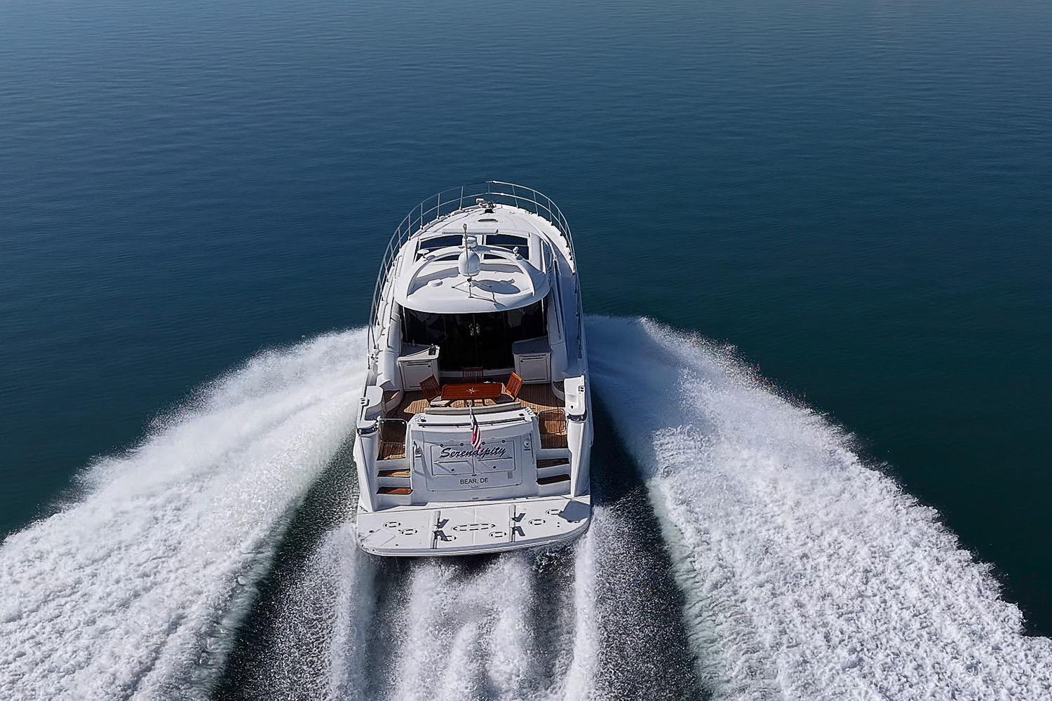 2008 Sea Ray 60 Sundancer yacht cruising on open water, aerial rear view.