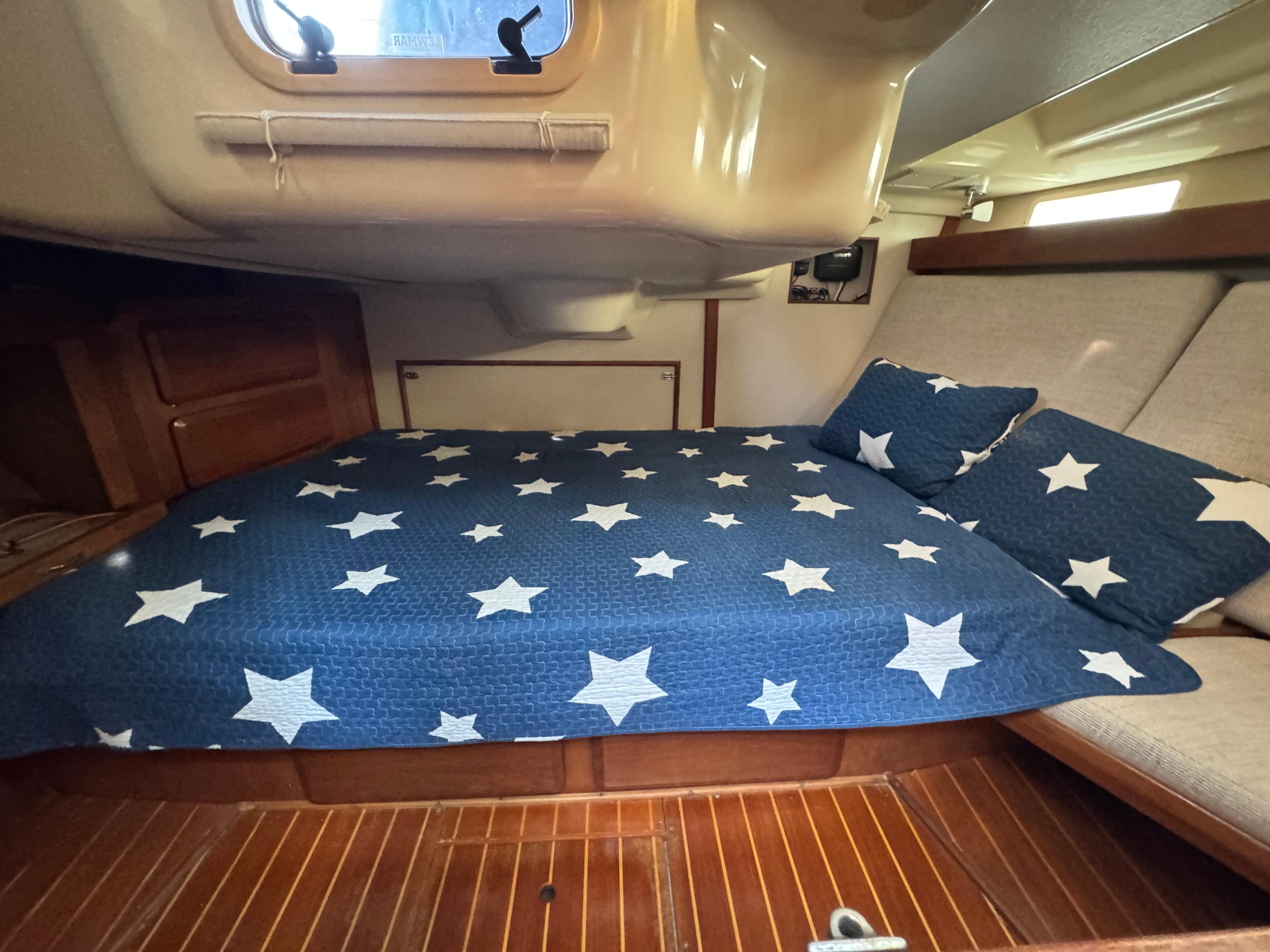 Cozy cabin interior of 1991 Hunter Vision 36 sailboat with star-patterned bedding.