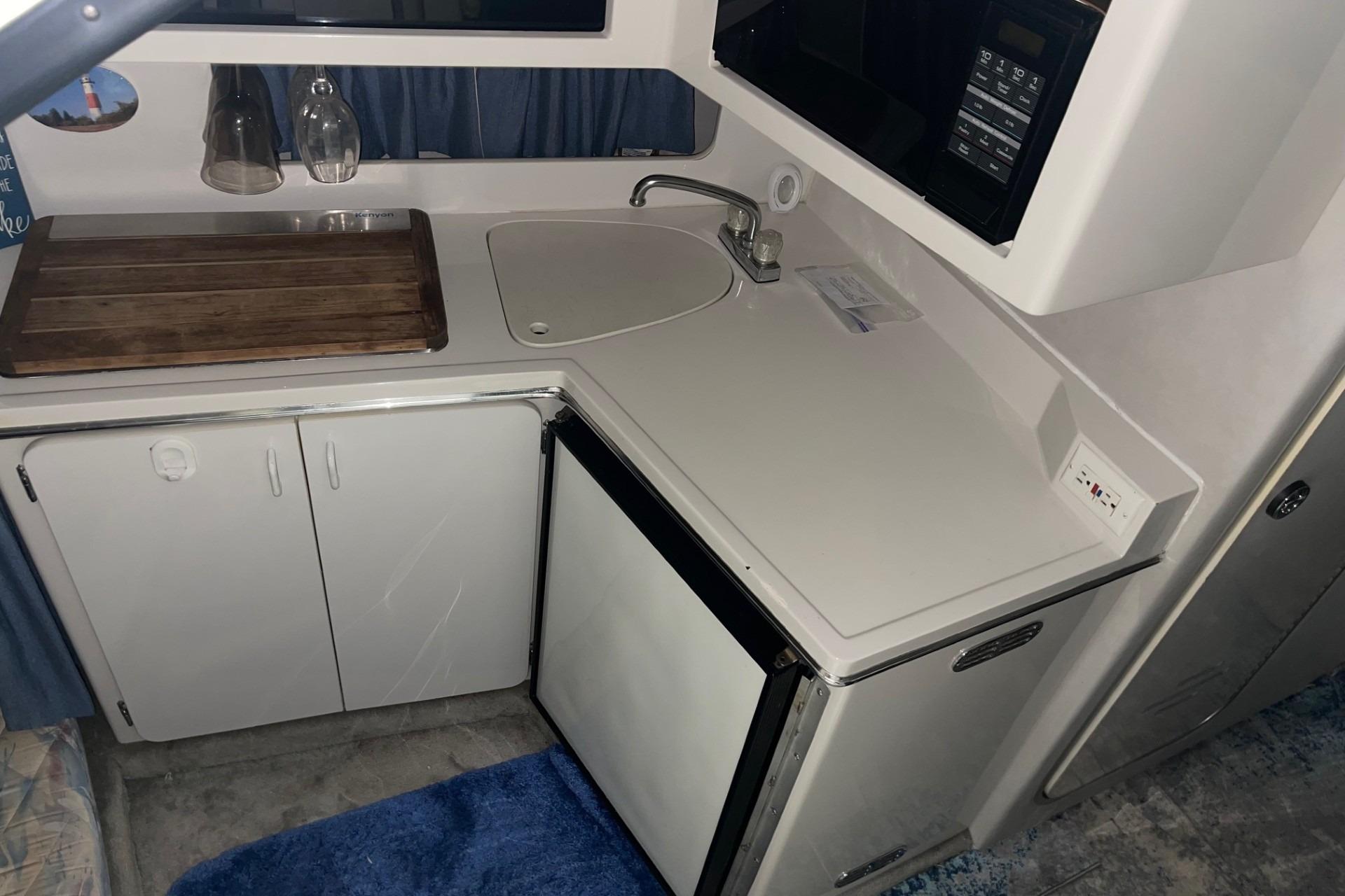 1992 Chaparral Signature 30 boat kitchen with sink, fridge, and microwave.