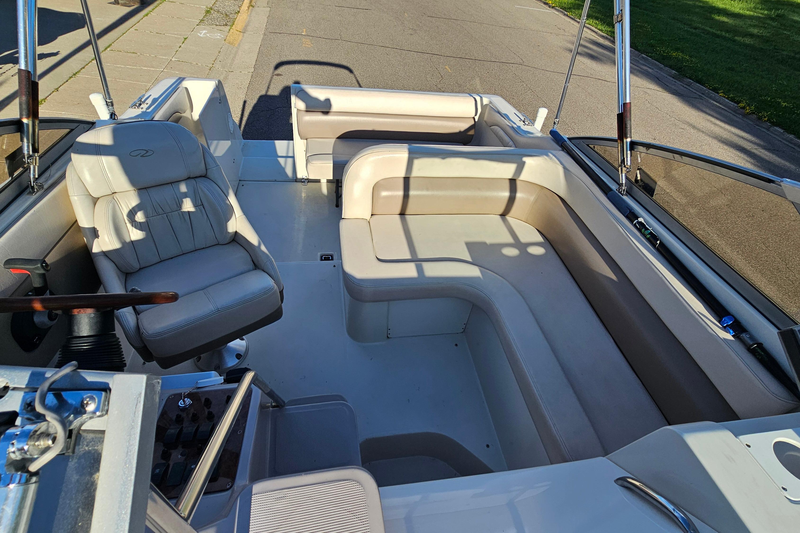 Interior of a 1999 Regal Commodore 258 boat with beige seating and steering wheel.