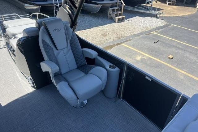 2024 Manitou 25 LX SRW boat interior with luxurious gray captain's chair and cup holder.