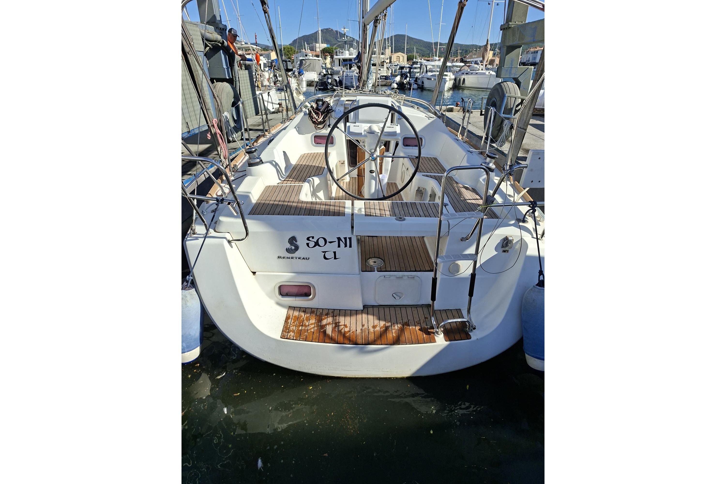 2013 Beneteau Oceanis 31 sailboat docked, featuring a spacious cockpit and steering wheel.