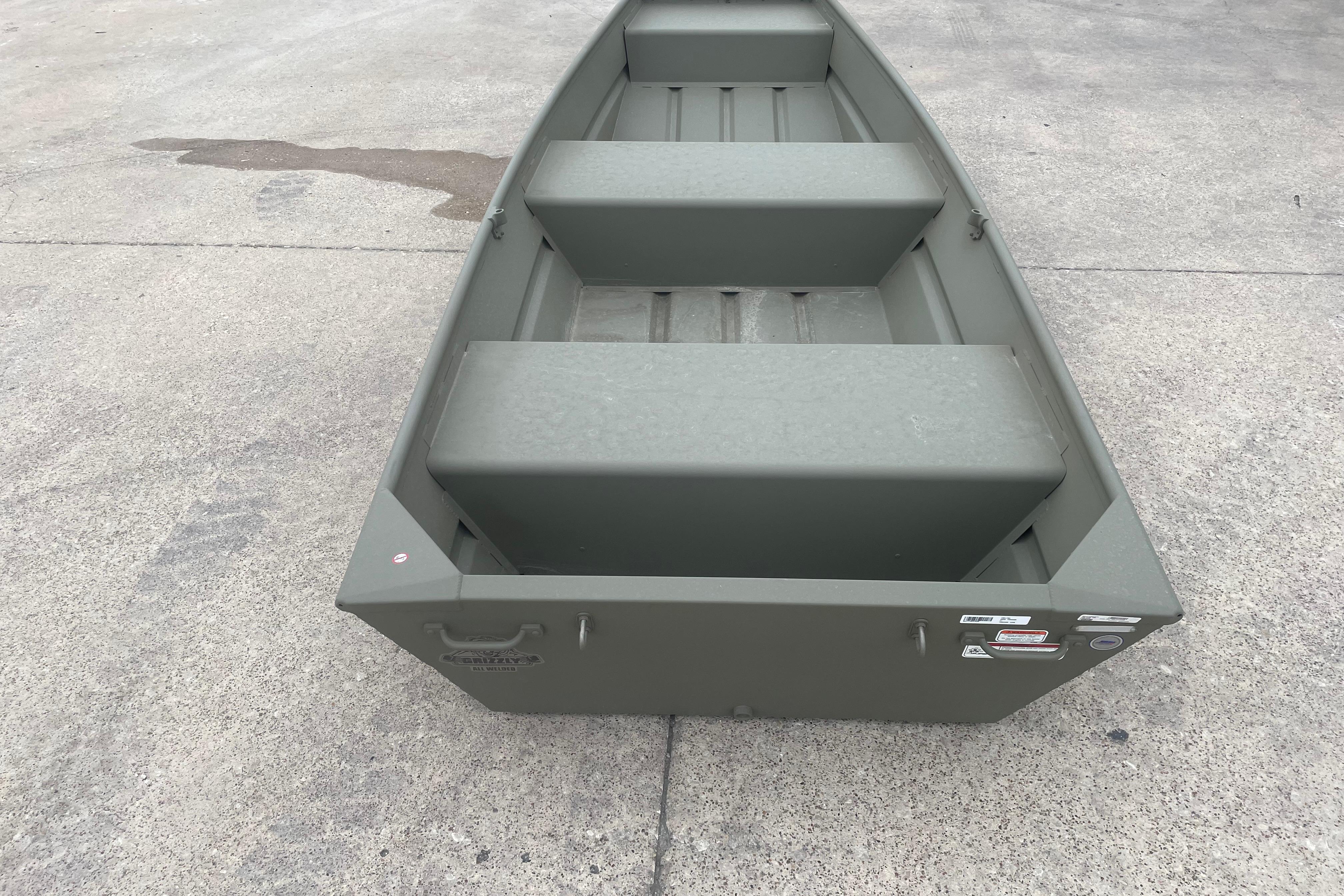 2026 Tracker Grizzly 12 Jon boat on concrete surface, showcasing its sturdy design.
