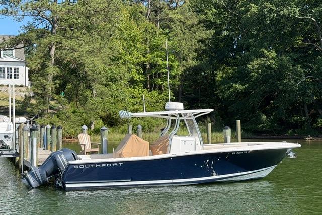 2014 Southport 29 FE boat docked by a lush, wooded shoreline.